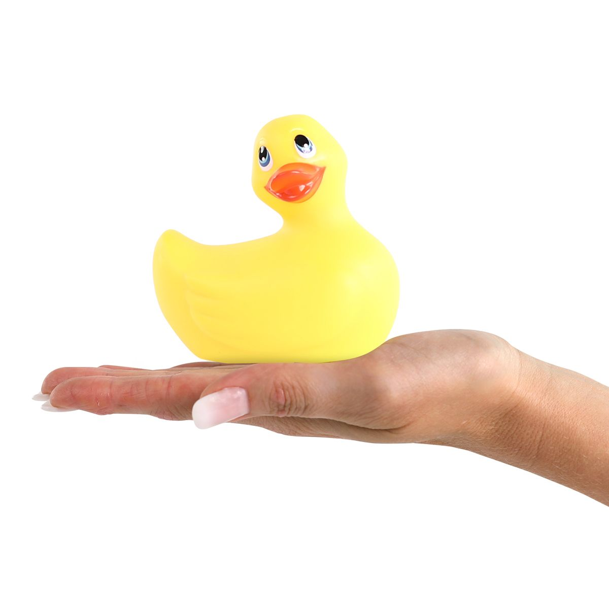 Eine gelbe Gummiente wird auf einer Hand vor weißem Hintergrund gehalten. Die Ente hat schwarze Augen und einen orangen Schnabel.