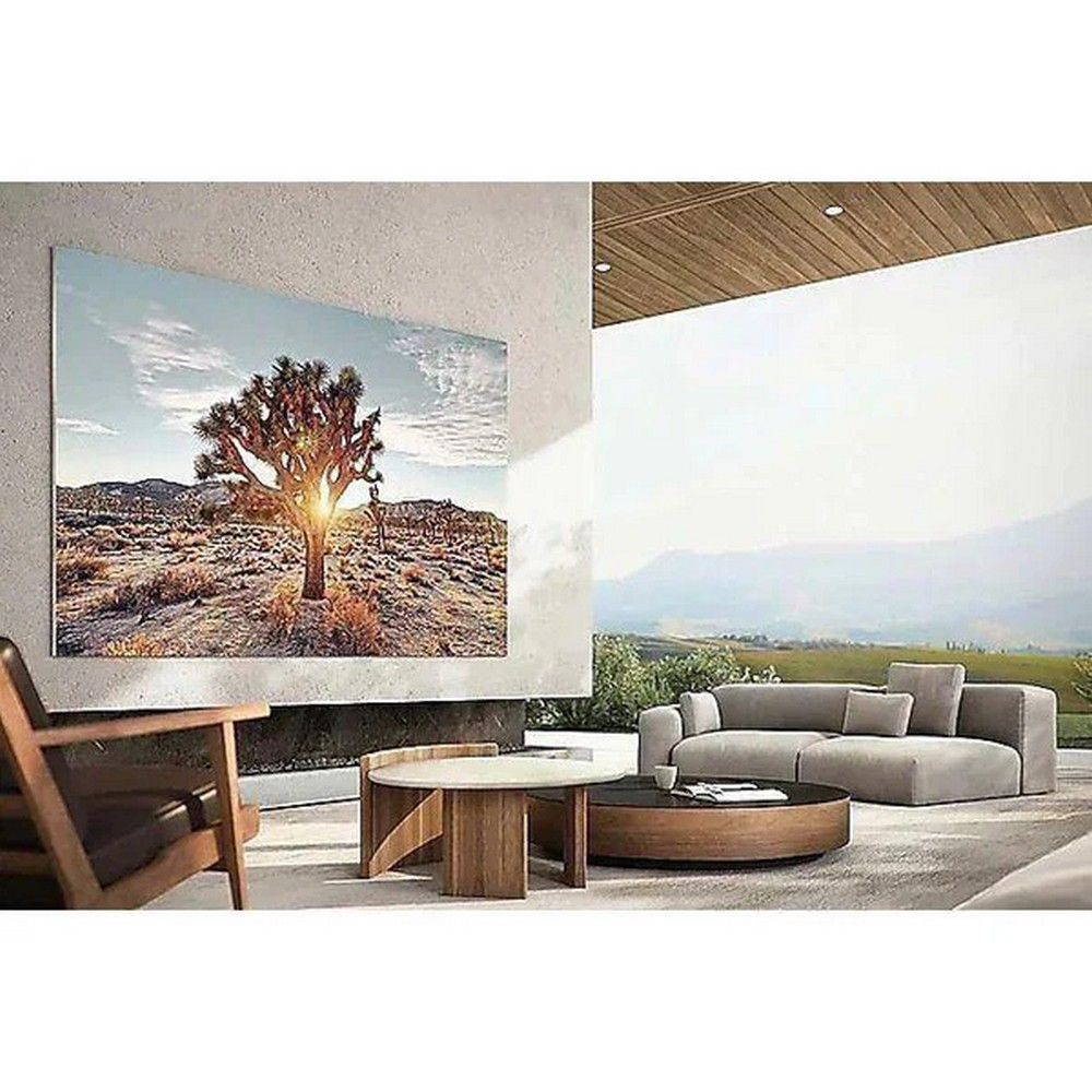 Soggiorno moderno con dipinto di paesaggio di albero di Giosuè, mobili in legno e vista sulle montagne.