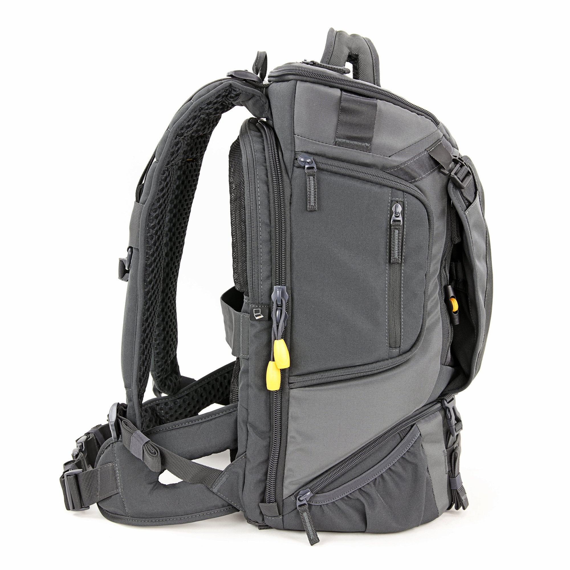 Ein grauer Rucksack mit mehreren Fächern, Reißverschlüssen und gelben Akzenten vor weißem Hintergrund. Seitenansicht.