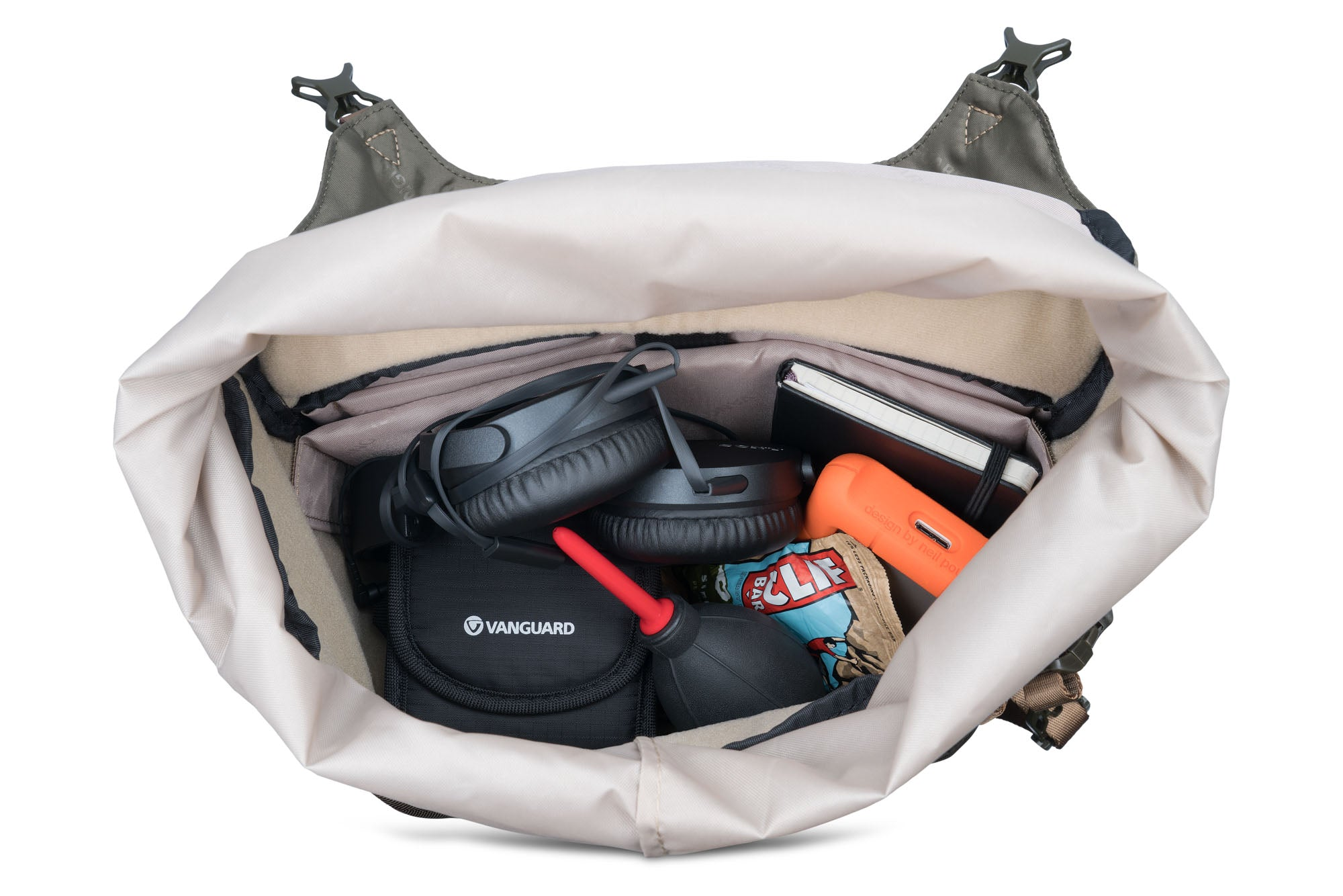 Mochila abierta llena de auriculares, cuaderno, dispositivo naranja, bocadillos y una funda negra Vanguard.