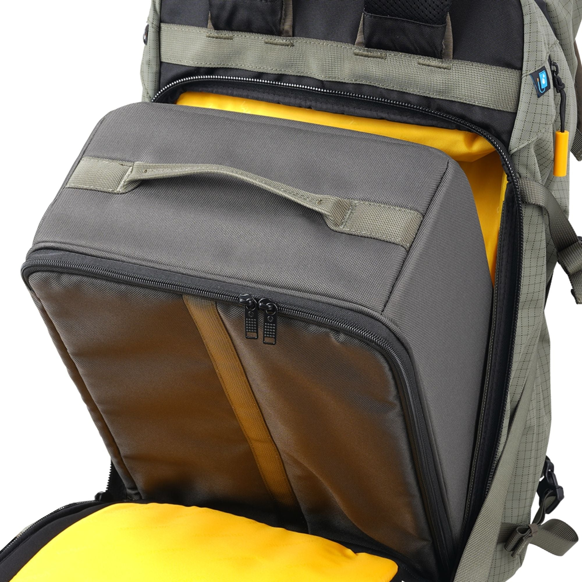 Ein grauer Kamerarucksack ist geöffnet und gibt den gelben Innenraum frei. Ein herausnehmbarer grauer Einsatz mit Griff ist innen.