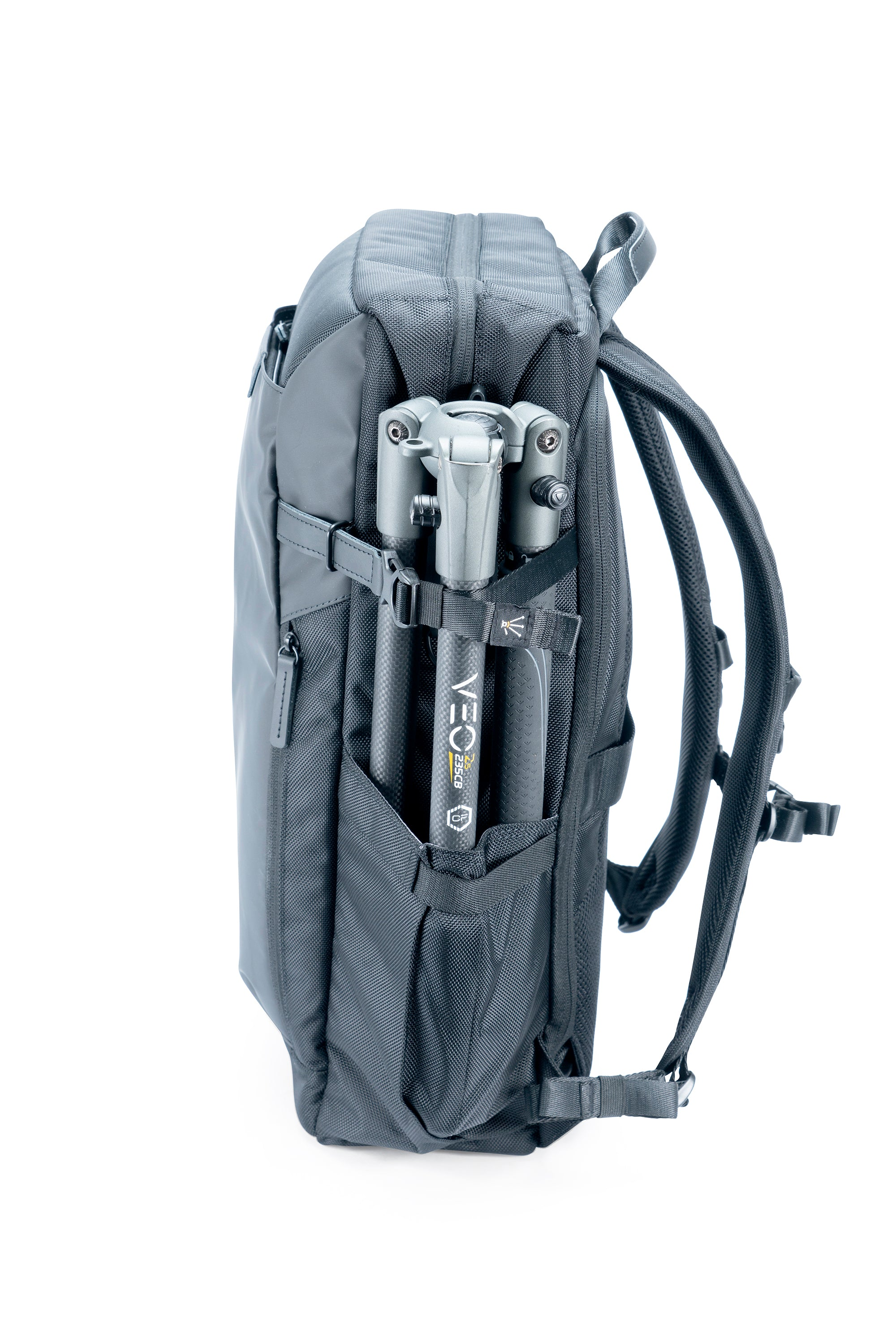 Ein grauer Rucksack mit einem Stativ in der Seitentasche. Das Stativ ist schwarz und grau. Weißer Hintergrund.