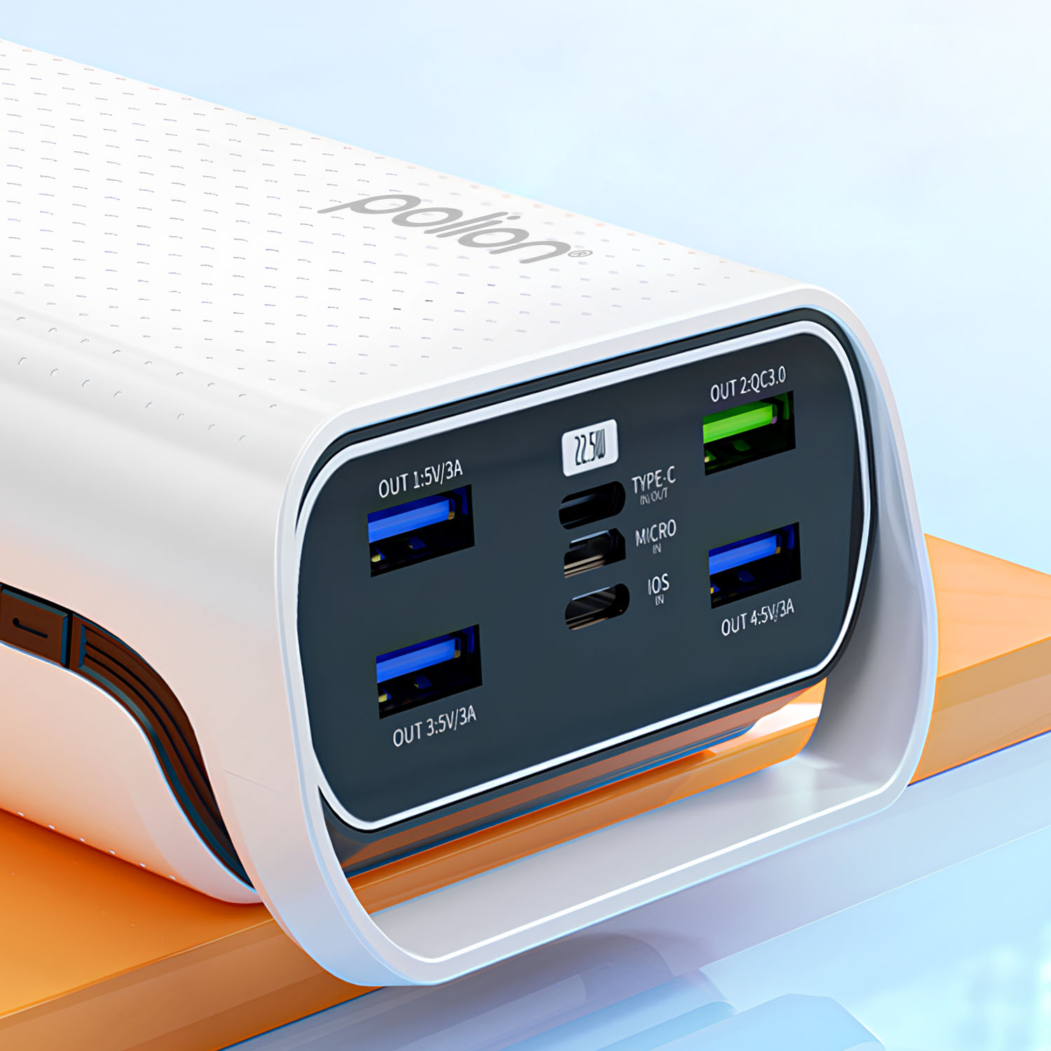 Biały power bank z wieloma portami wyjściowymi. Zawiera porty USB, Type-C i Micro. Znajduje się na pomarańczowej i niebieskiej powierzchni.