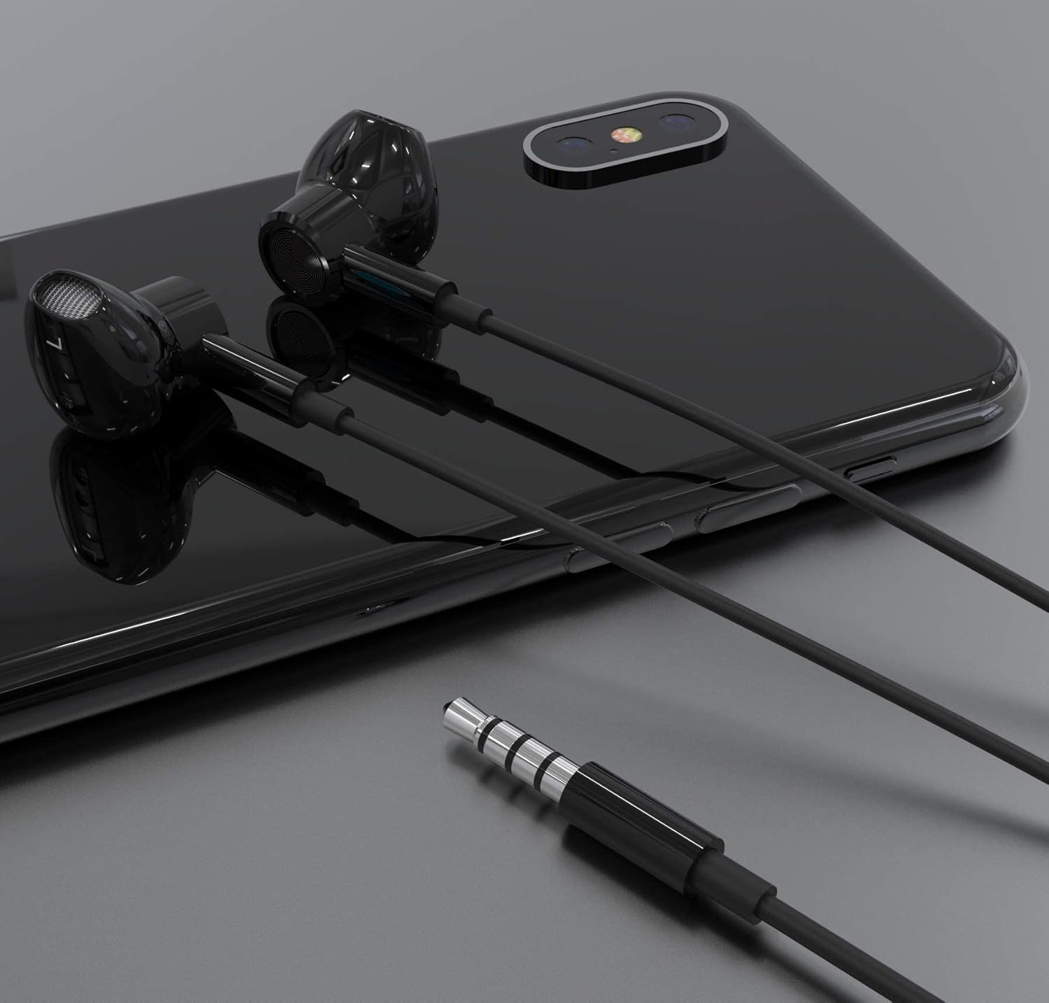 Schwarze Ohrhörer mit schwarzem Kabel und einem silbernen Stecker liegen auf einem schwarzen Telefon. Das Telefon liegt auf einer grauen Oberfläche.