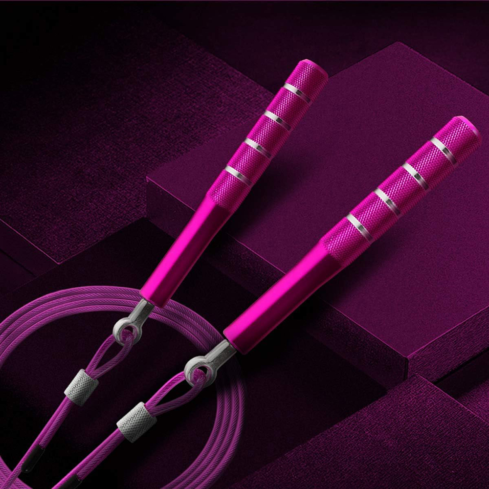 Zwei pinke Springseilgriffe mit silbernen Akzenten und ein pinkes Seil vor einem dunkelviolett strukturierten Hintergrund.