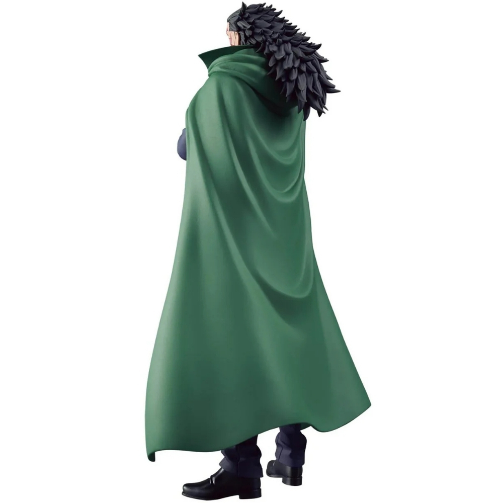 Figura de un hombre con capa verde. Tiene pelo negro y usa zapatos y pantalones negros. El fondo es blanco.
