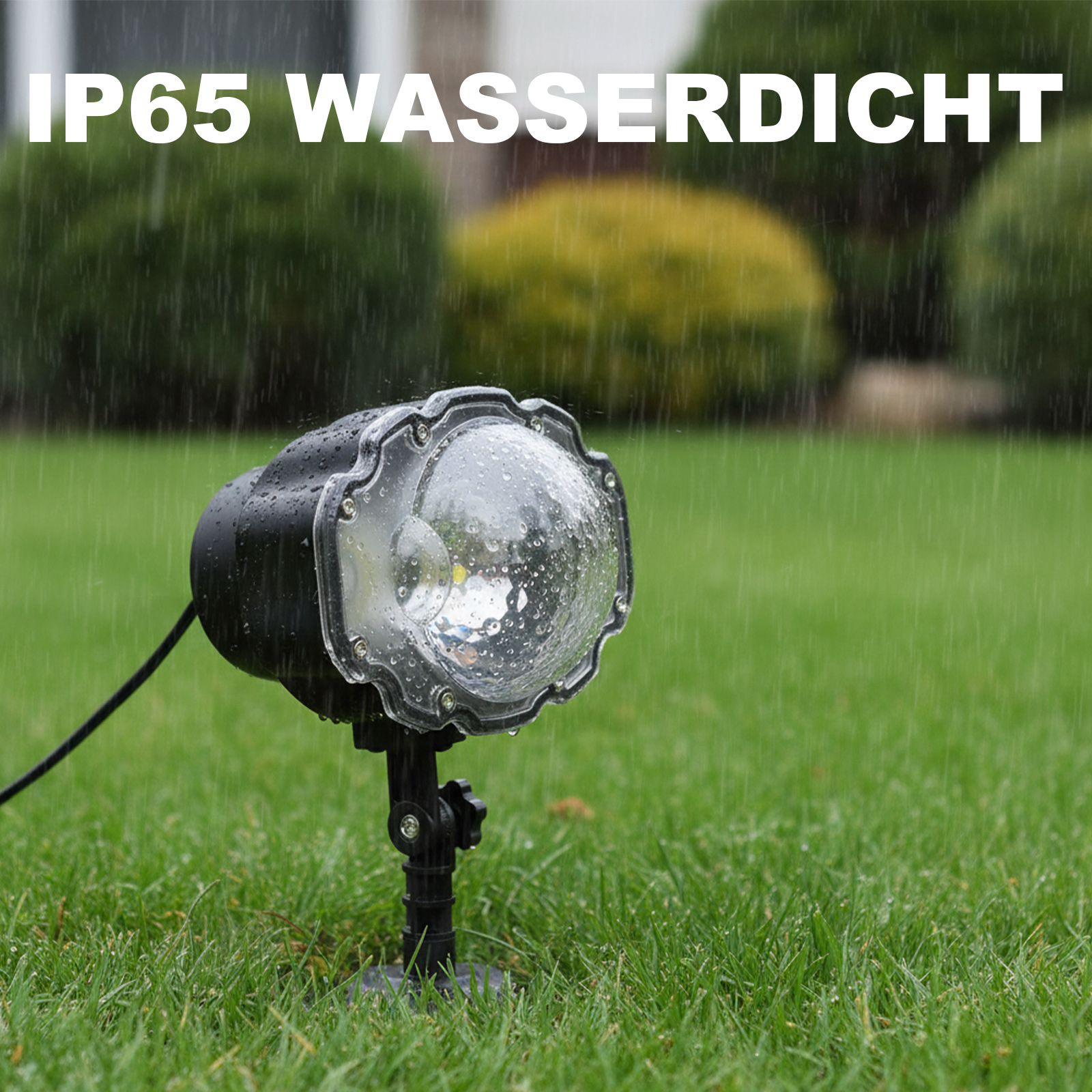Ein wasserdichter Scheinwerfer im Regen, auf grünem Gras. Oben steht IP65 WASSERDICHT. Im Hintergrund Büsche.