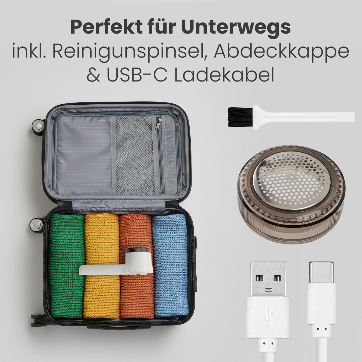 Offener Koffer mit bunten, gerollten Kleidungsstücken, Fusselentferner, Bürste und USB-Kabeln. Text: Perfekt für unterwegs.