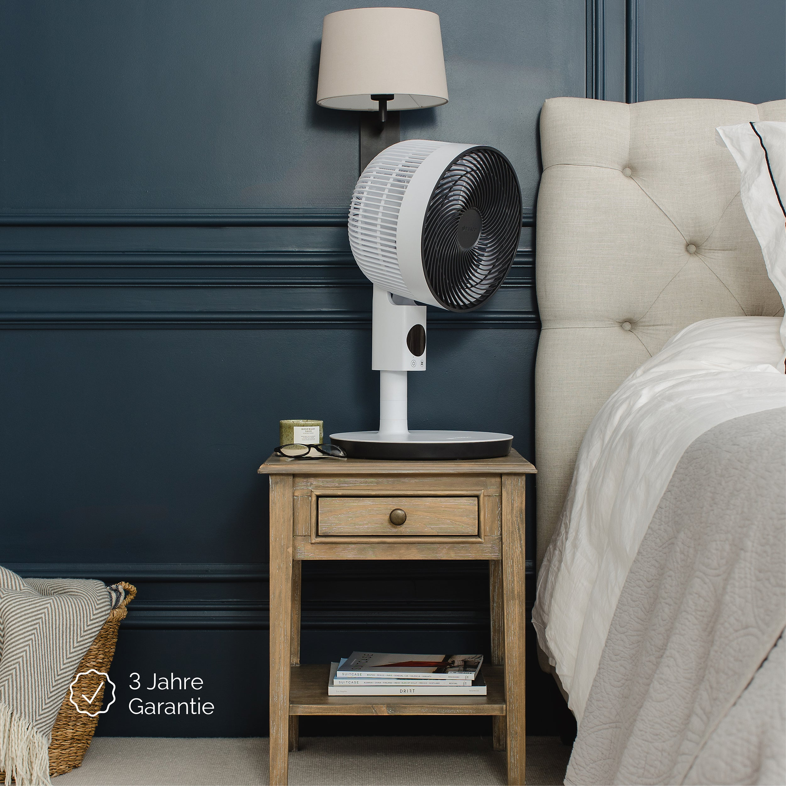 Scena sypialni z wentylatorem na stoliku nocnym. Po prawej łóżko, ściana granatowa.