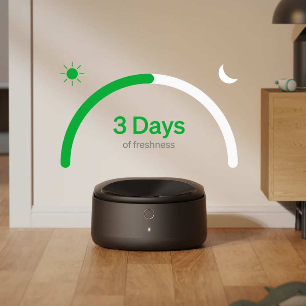 Un ambientador oscuro y circular con un botón. La imagen tiene un arco verde, iconos de sol y luna, y texto: 3 días de frescura.