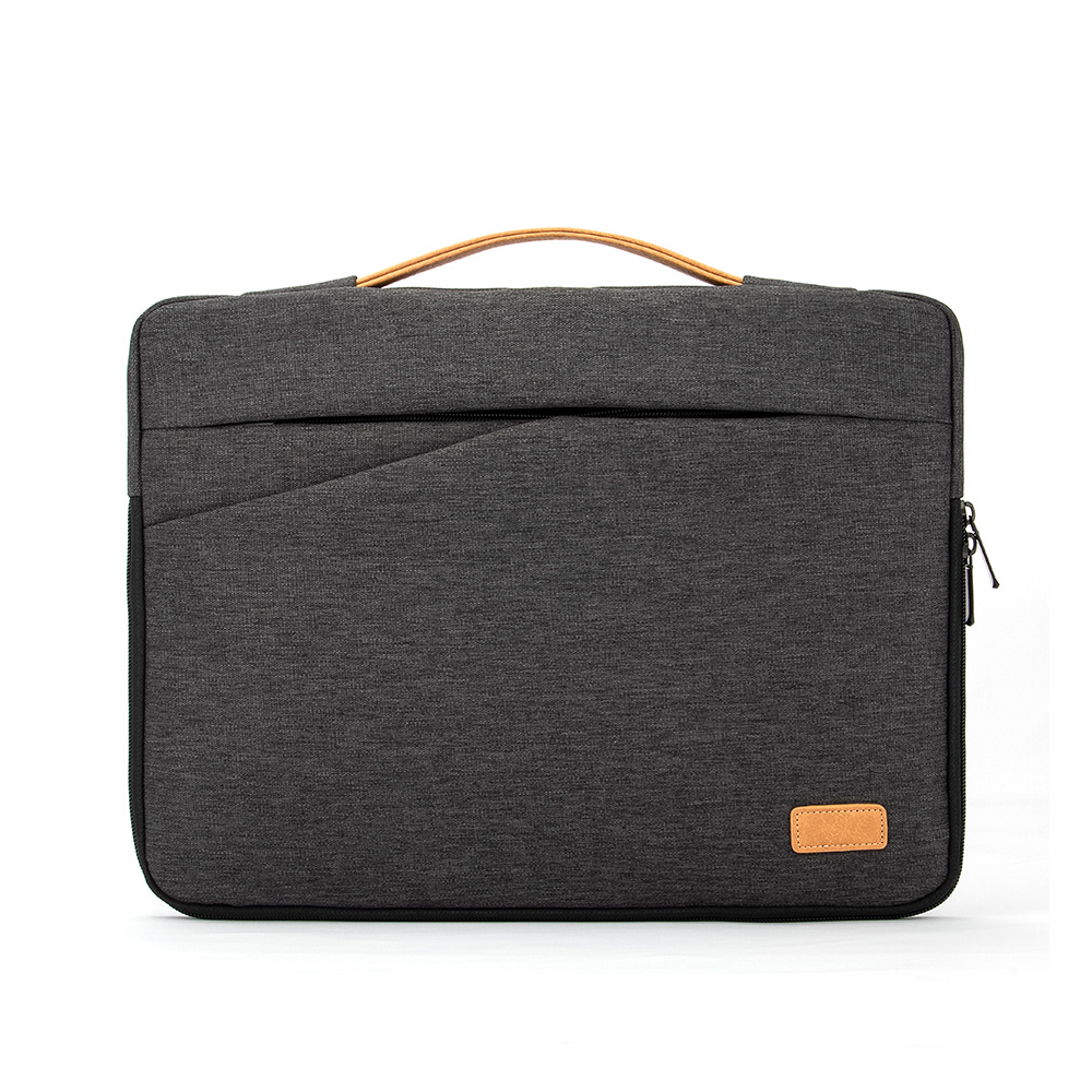 Eine graue Laptoptasche mit braunem Griff und einem kleinen, braunen Etikett. Sie hat einen Reißverschluss und eine Tasche.