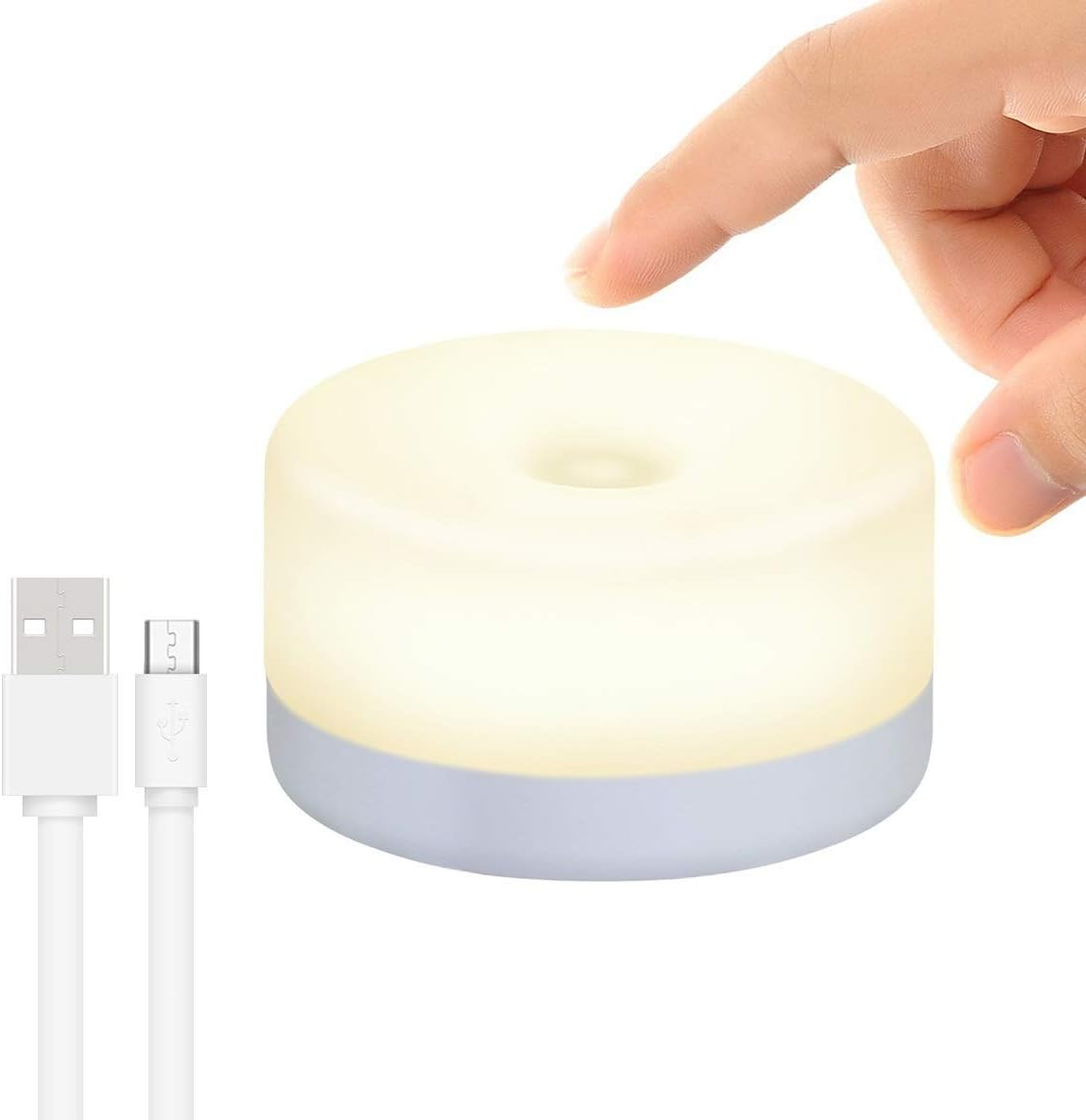 Eine Hand berührt eine leuchtende weiße Lampe. Links sind ein USB-Kabel und ein Micro-USB-Kabel. Die Lampe hat einen hellblauen Sockel.
