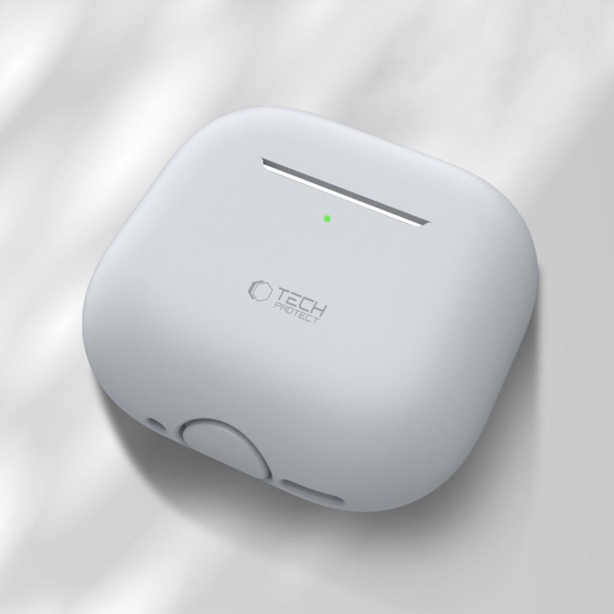 A white AirPods case with a green light and Tech Protect logo. It's on a white surface with subtle light and shadow.