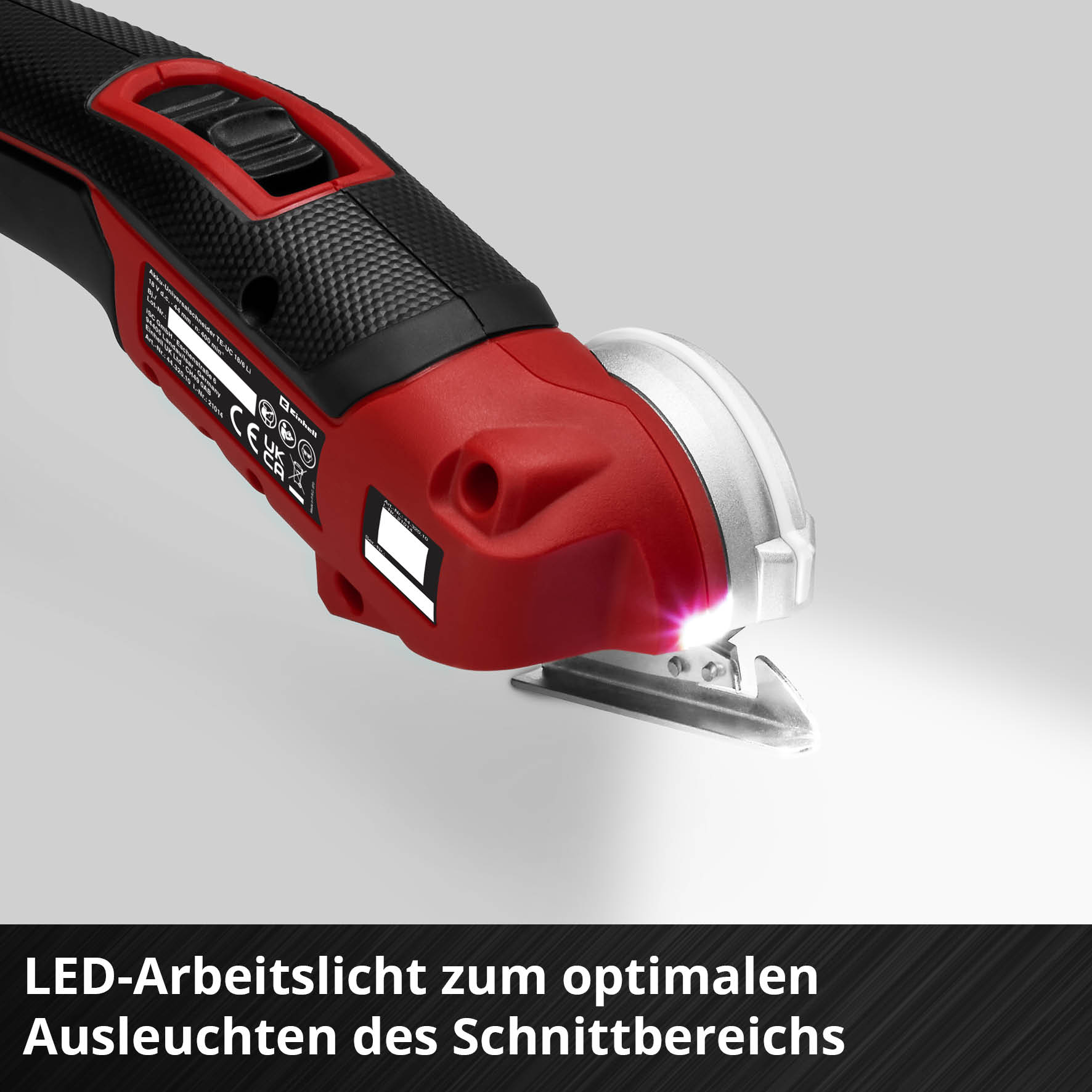 Ein rot-schwarzes kabelloses Schneidwerkzeug mit hellem LED-Licht, das die Klinge beleuchtet.
