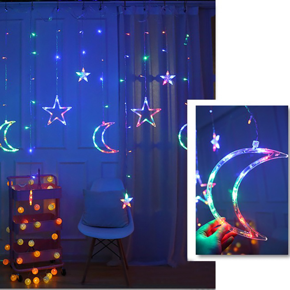 Ein Raum mit stern- und mondförmigen Lichterketten. Ein kleiner Wagen mit Lichtern und ein Stuhl stehen vor dem Fenster.