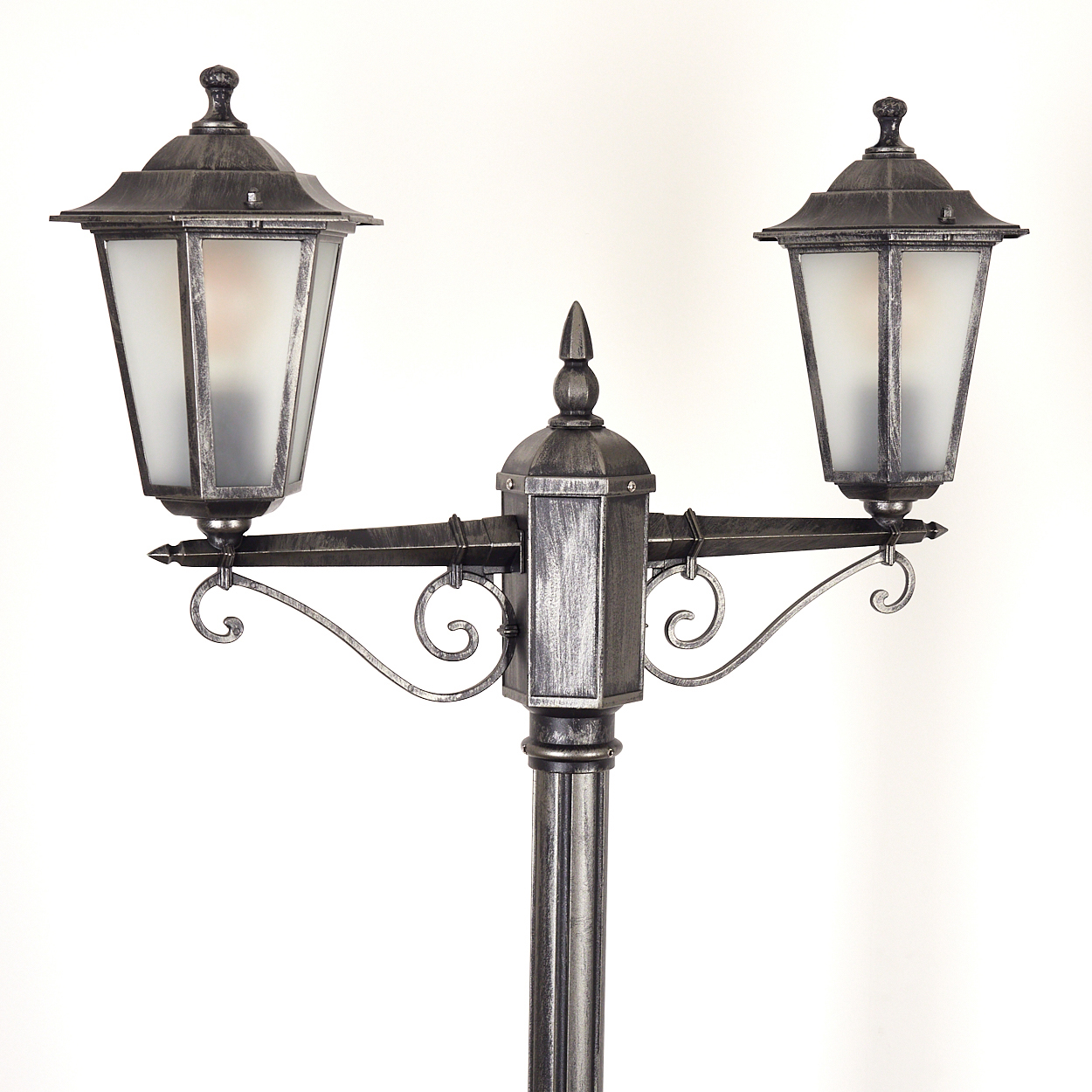 Eine dekorative Außenlampe mit zwei matten Glasschirmen, kunstvollen Metallarbeiten und einem zentralen Pfosten vor weißem Hintergrund.
