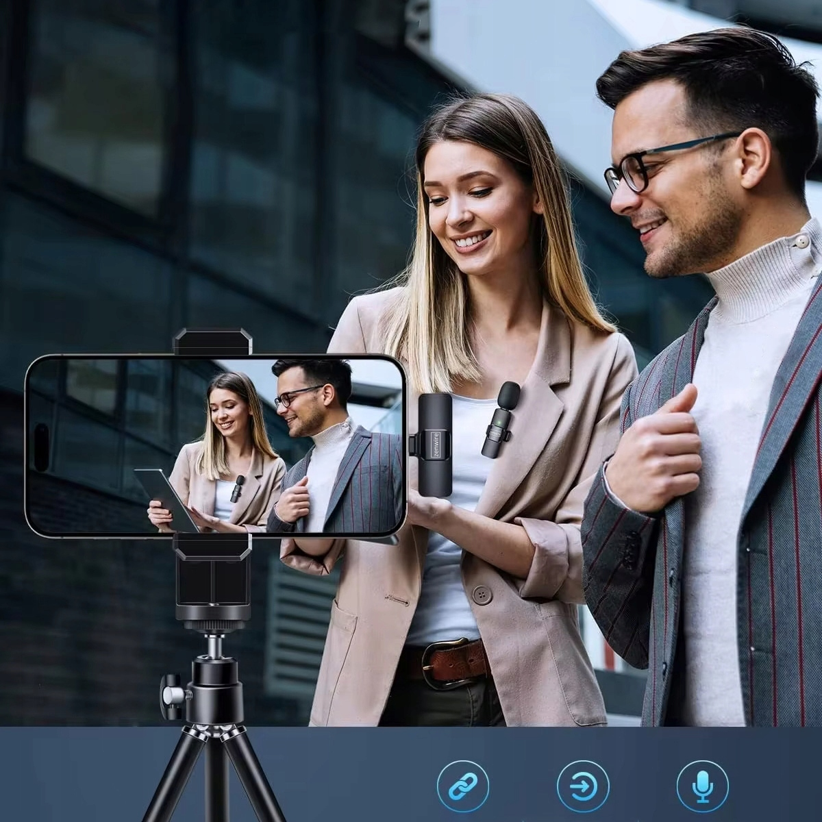 Kobieta i mężczyzna trzymają mikrofon. W tle smartfon na statywie pokazuje te same osoby.