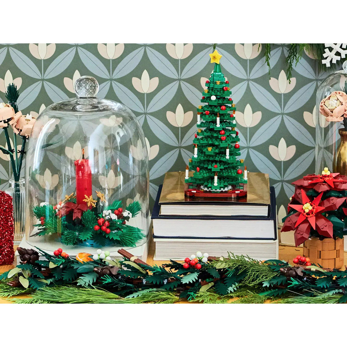 Lego ağacı, cam kubbede mum ve poinsettias ile Noel sahnesi. Ön planda çelenk, arka planda çiçek deseni.