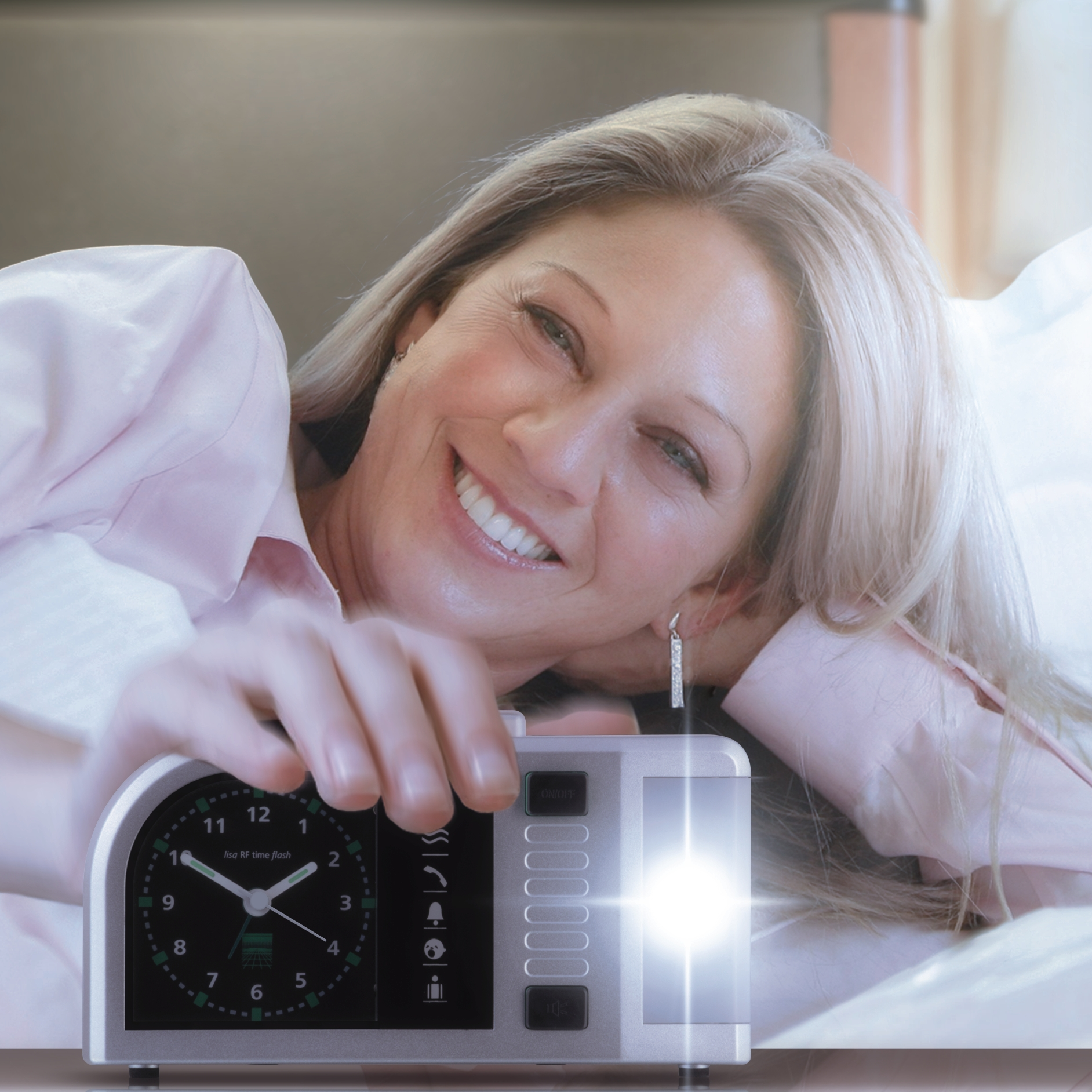Eine lächelnde Frau im Bett greift nach einem leuchtenden Wecker. Sie hat blondes Haar und trägt ein rosa Hemd.