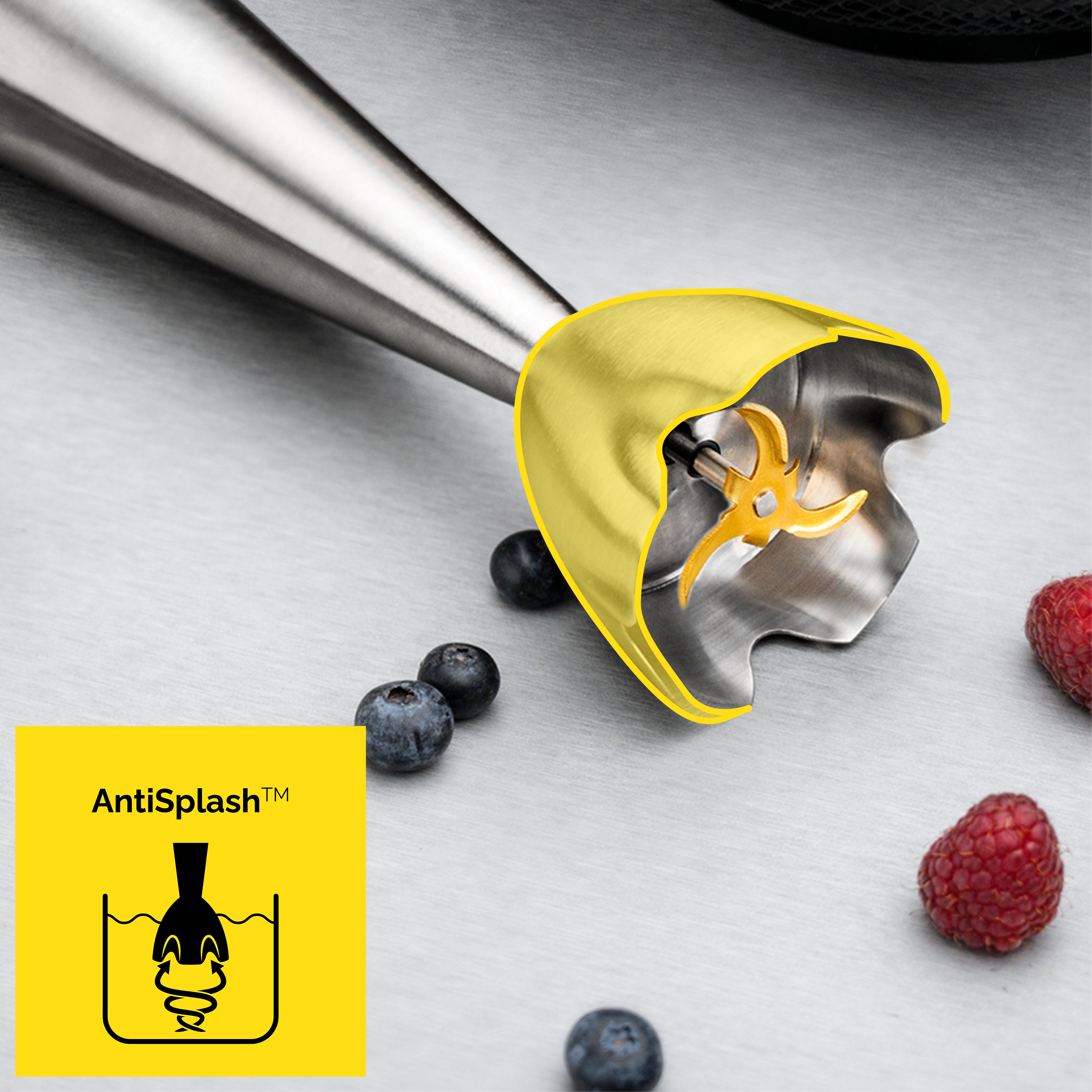 Blender ręczny z żółtą osłoną i ostrzami, borówkami i maliną. Logo "AntiSplash" w rogu.