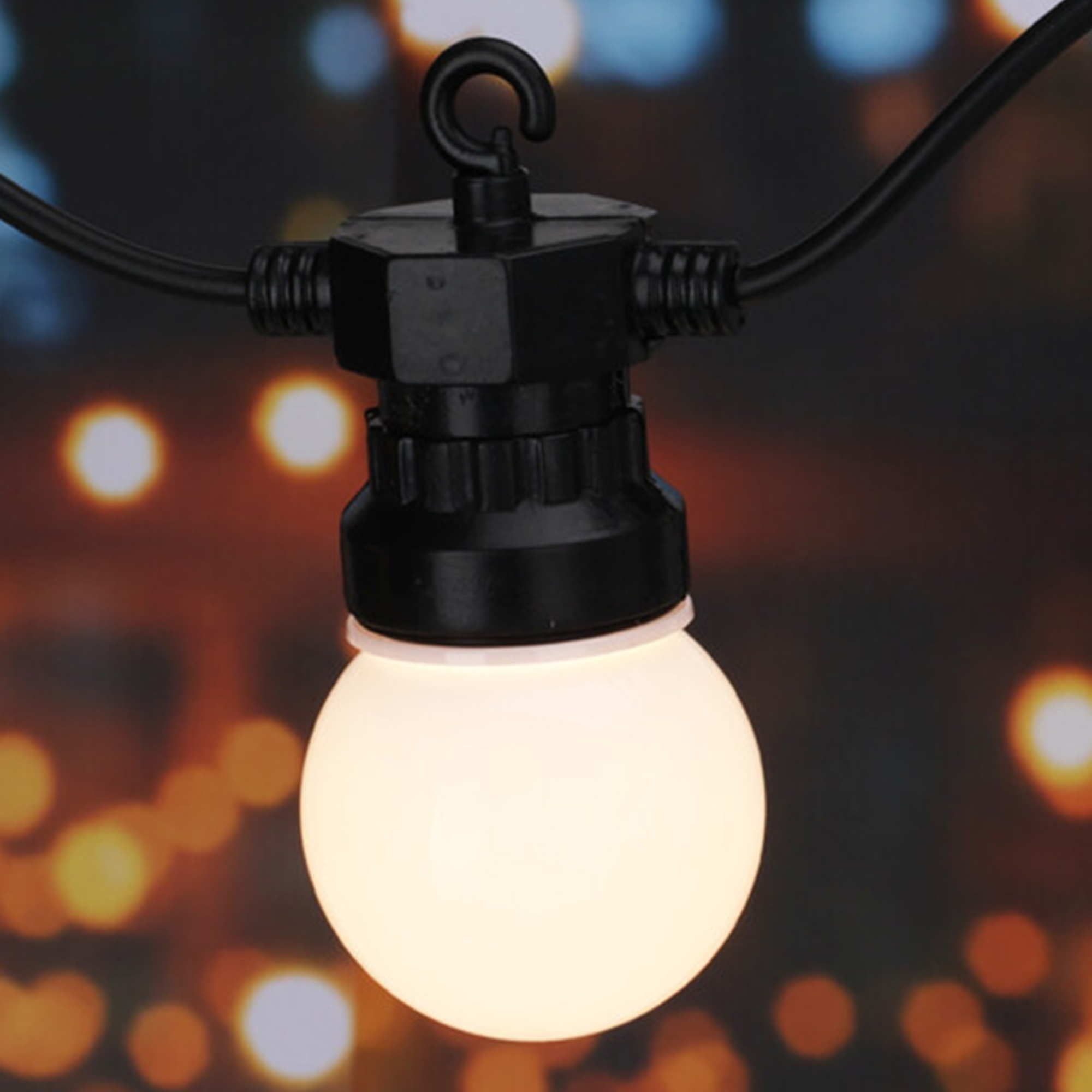 Primer plano de una guirnalda de luces negra. Tiene una bombilla redonda y encendida. El fondo está borroso con bokeh.