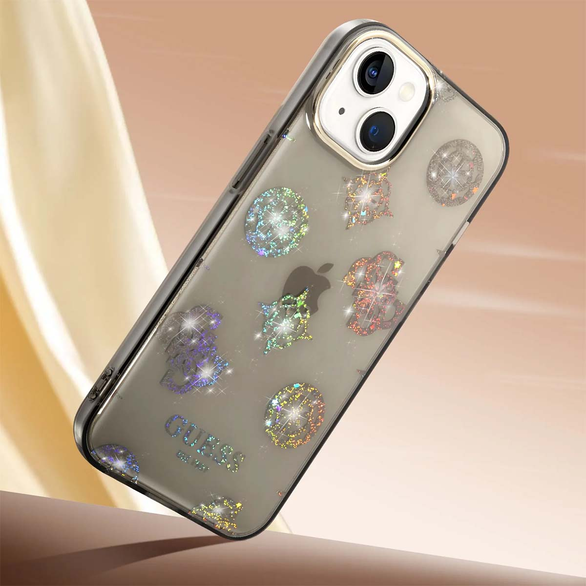 Un iPhone con custodia glitterata. La custodia presenta varie forme scintillanti e il logo Guess. Lo sfondo è un gradiente beige e marrone.