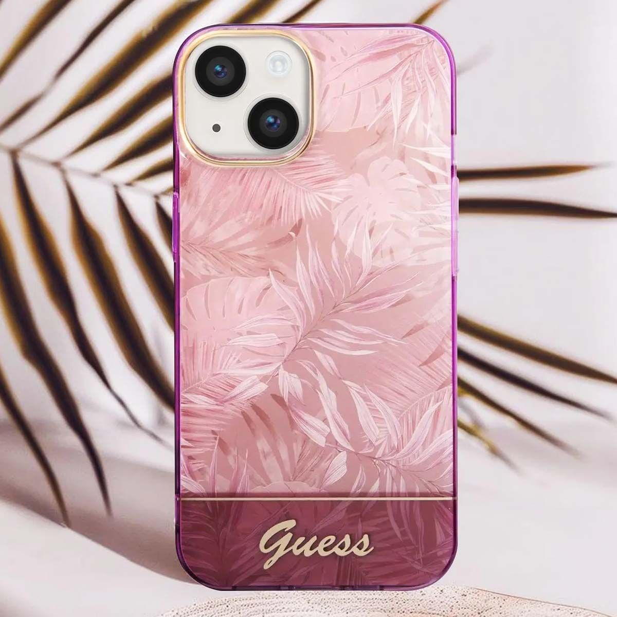 Rosa Handyhülle mit floralem Design und Guess-Logo. Der Hintergrund zeigt ein verschwommenes Palmenblatt.