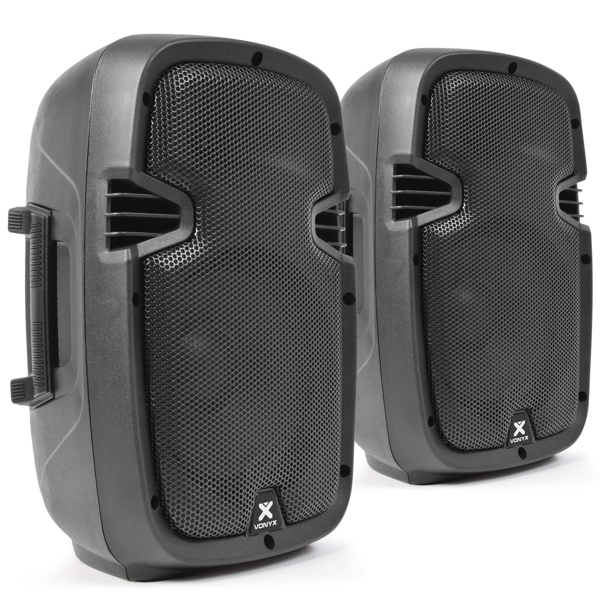 Dos altavoces Vonyx negros. Cada uno tiene una parte frontal de malla, ventilaciones y un asa. El fondo es blanco.