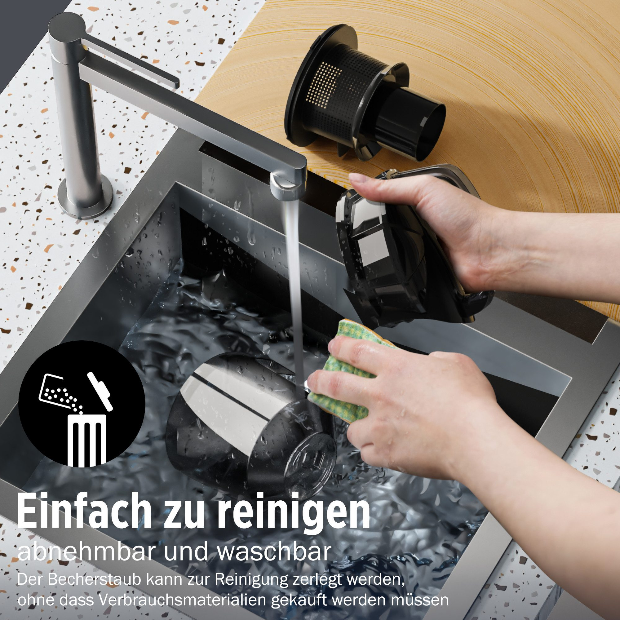 Eine Person wäscht ein Staubsaugerteil unter einem Wasserhahn. Das Teil und der Schwamm sind in einem Waschbecken.