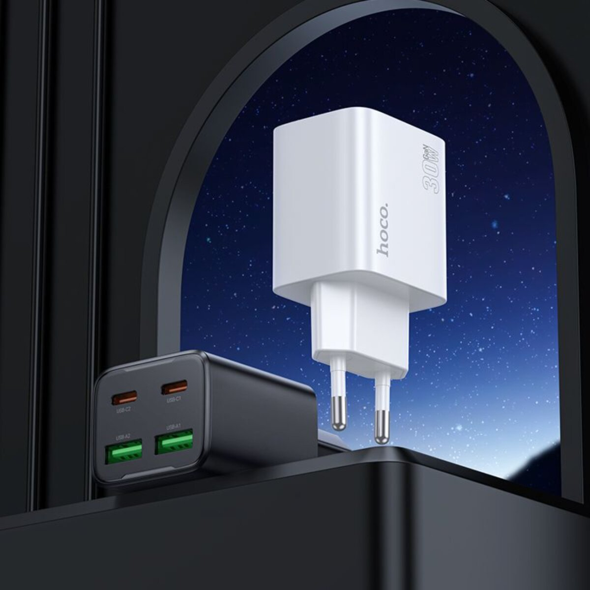 Een witte en zwarte oplader met meerdere USB-poorten. De witte oplader heeft het merk 'hoco.' en '30W' erop gedrukt.