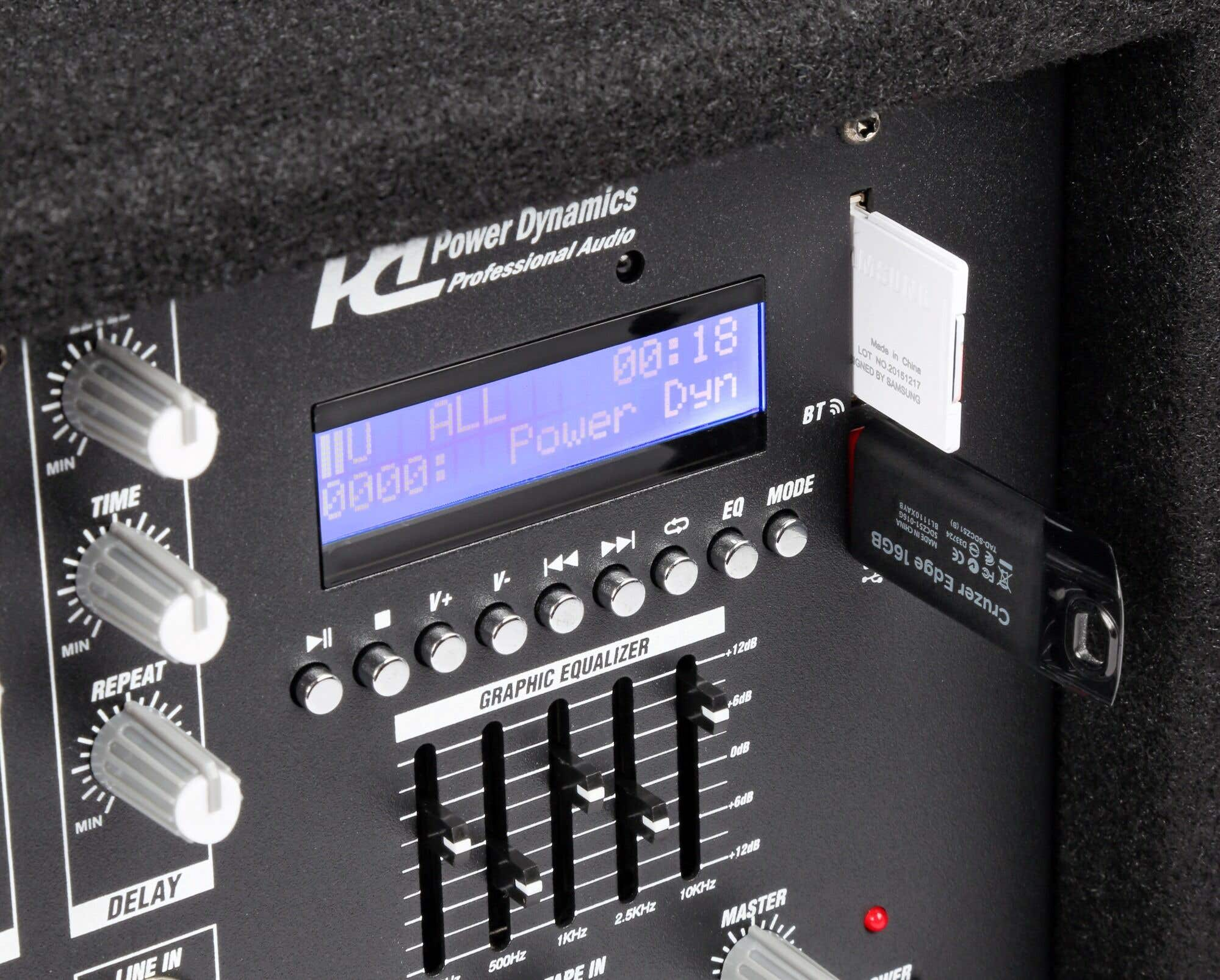Primer plano de un dispositivo de audio negro con pantalla y botones, con una unidad USB y una tarjeta SD.