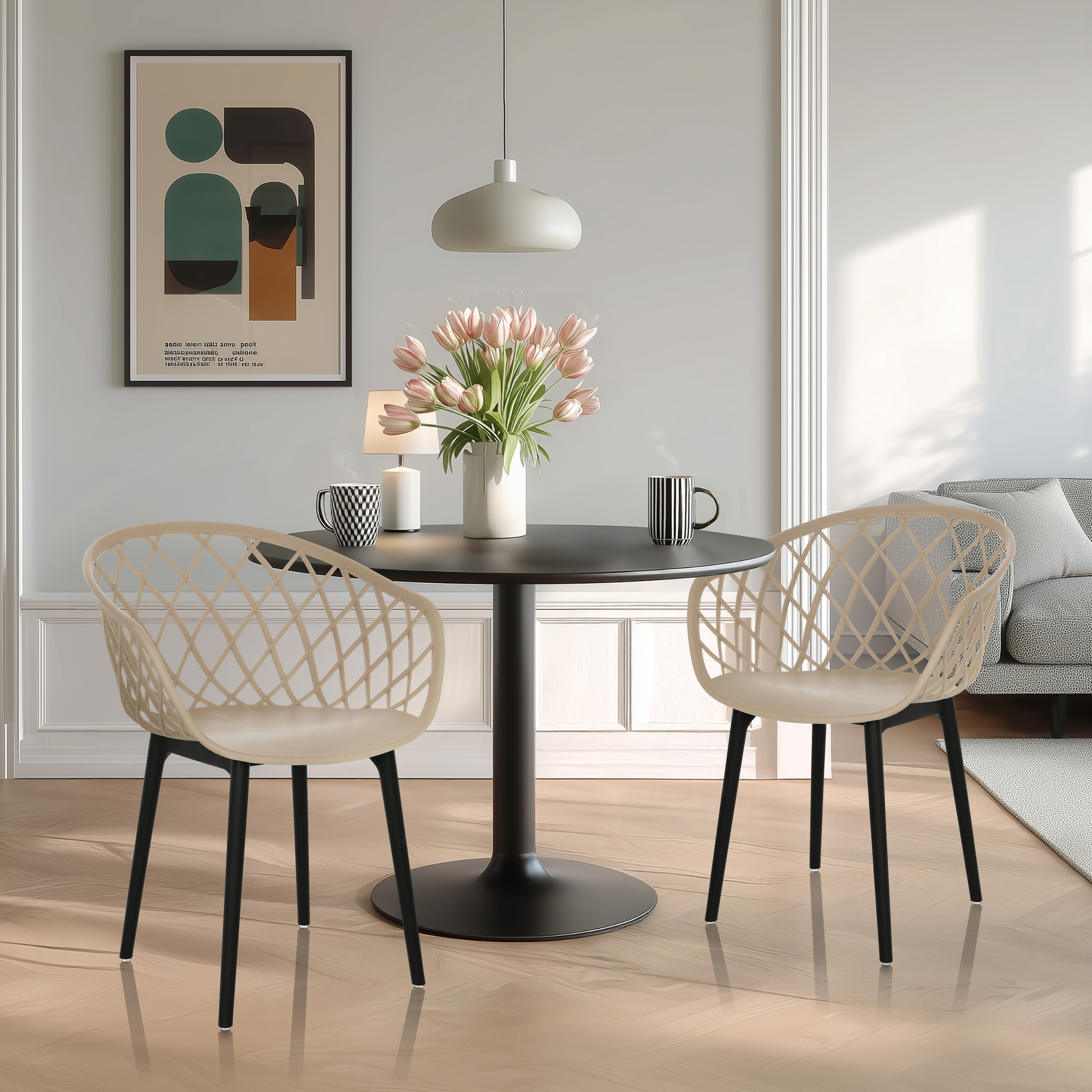 Esszimmer mit rundem Tisch, zwei Stühlen, einer Blumenvase und Kunst an der Wand.