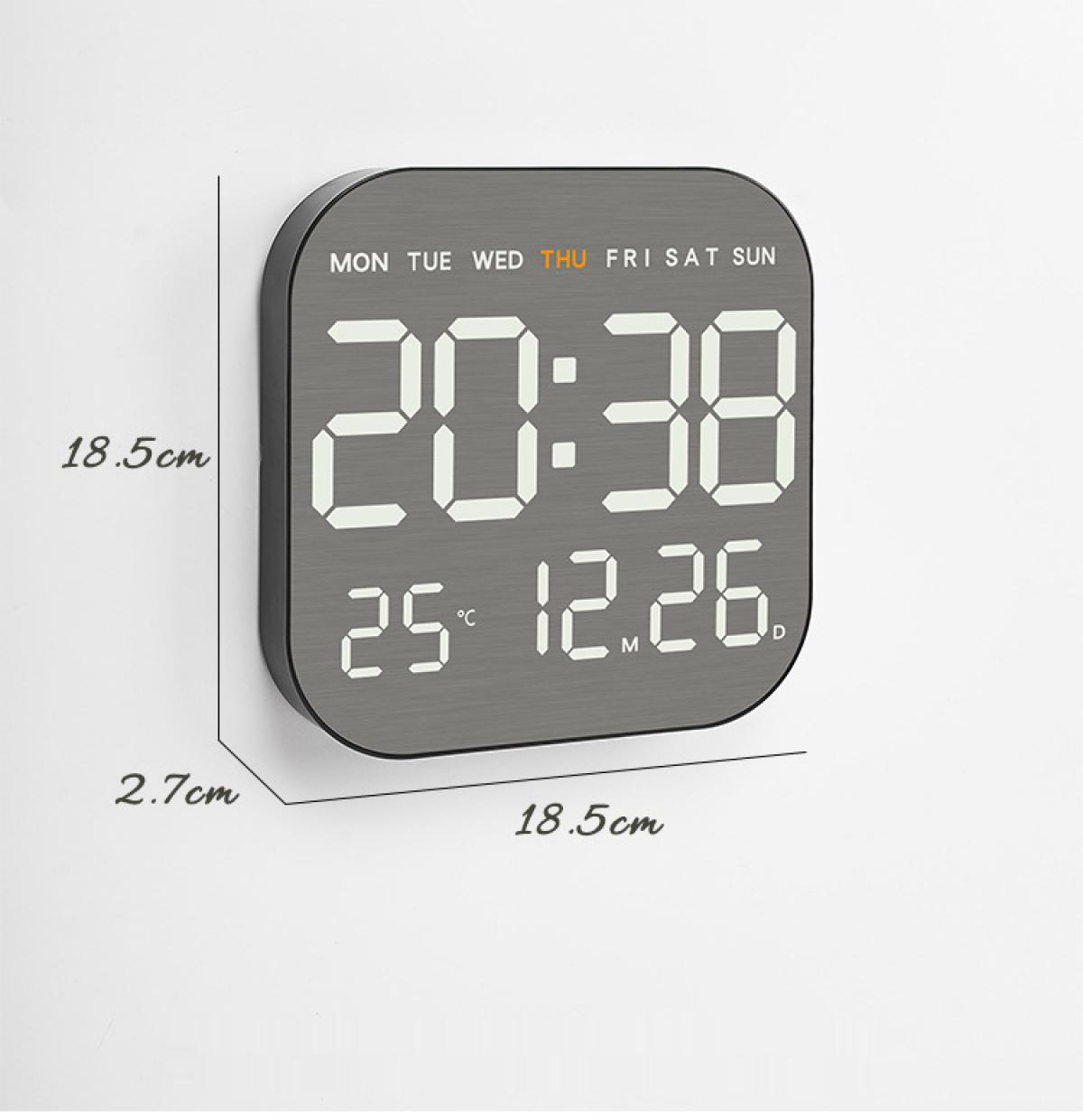 Eine graue Digitaluhr zeigt 20:38 und 25°C 12.26 an. Die Wochentage stehen oben. Die Abmessungen betragen 18,5x18,5x2,7 cm.
