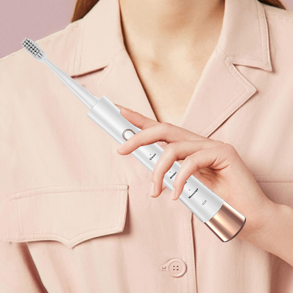 Eine Person hält eine weiße elektrische Zahnbürste. Sie hat einen roségoldenen Sockel. Die Person trägt ein rosa Hemd. Der Hintergrund ist ein sanftes Rosa.