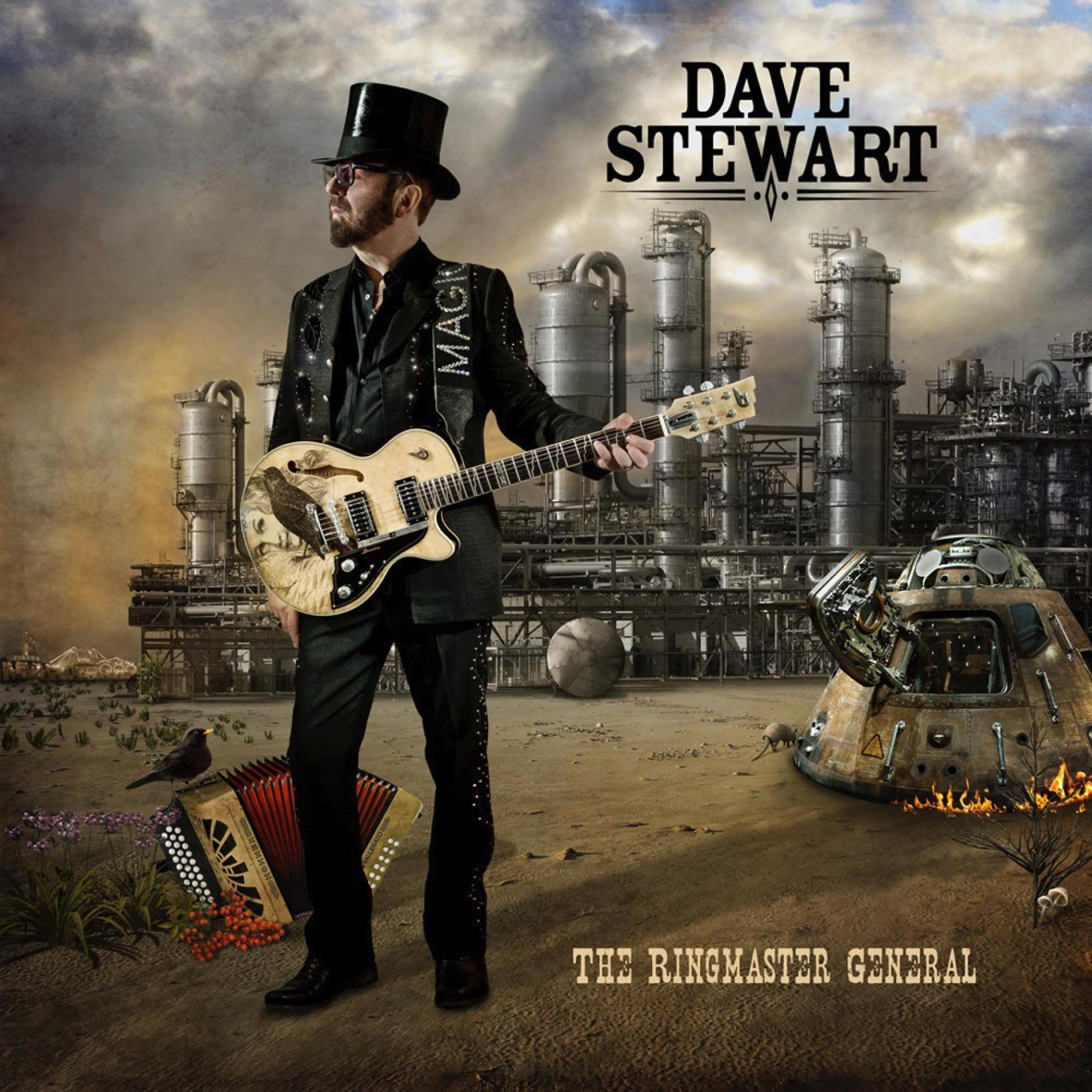 Dave Stewart mit Gitarre und Zylinder in Wüstenlandschaft mit Industrieanlagen und abgestürztem Raumschiff.