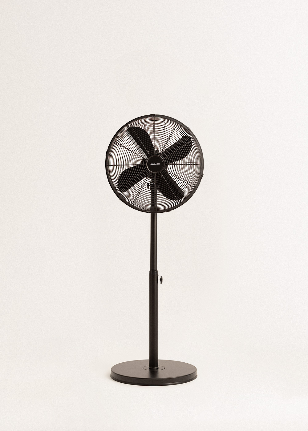 Un ventilador de pie negro con cuatro aspas está centrado sobre un fondo blanco.