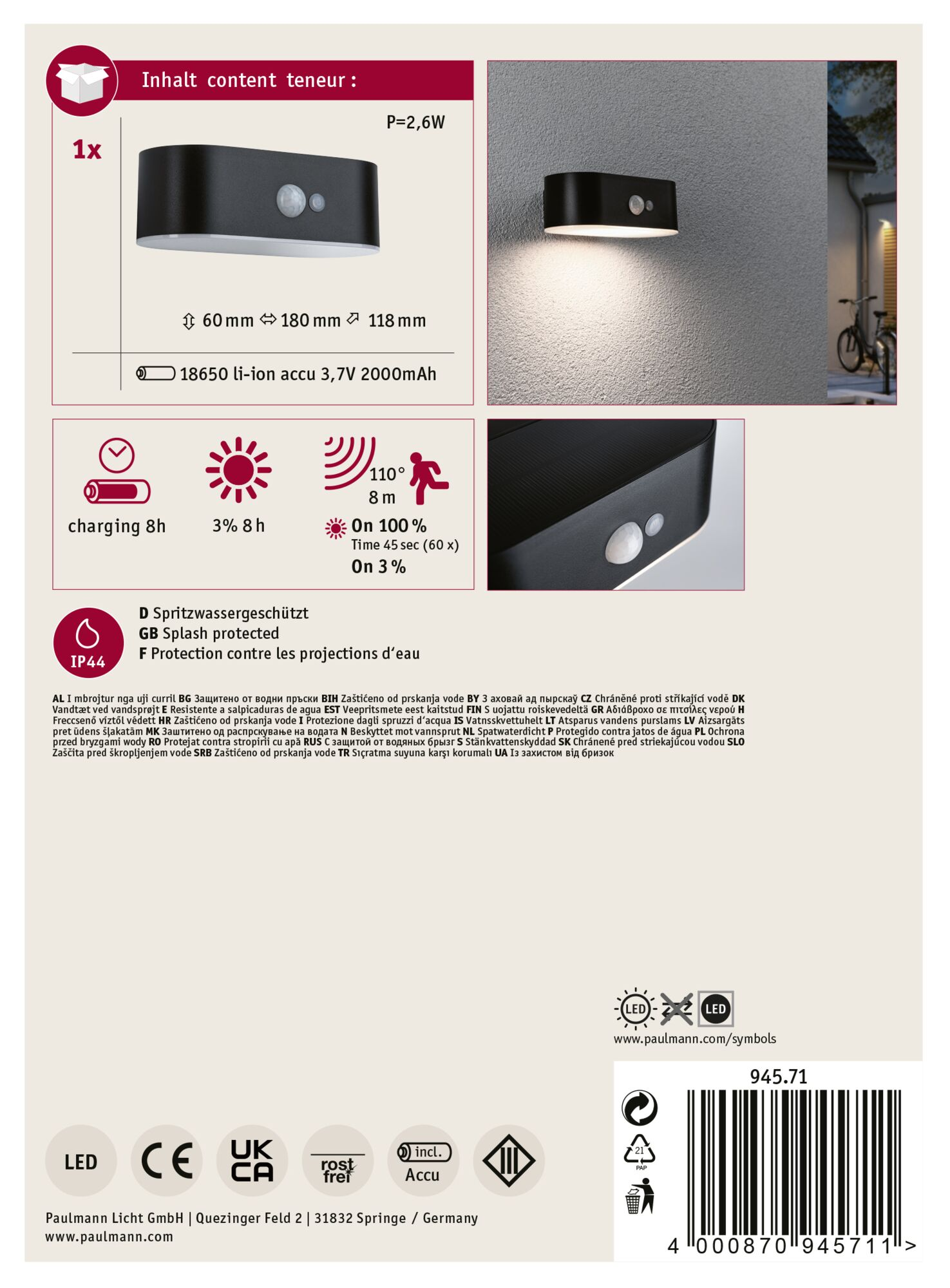 Czarna zewnętrzna lampa ścienna z czujnikiem ruchu, informacje o produkcie i rower w tle.