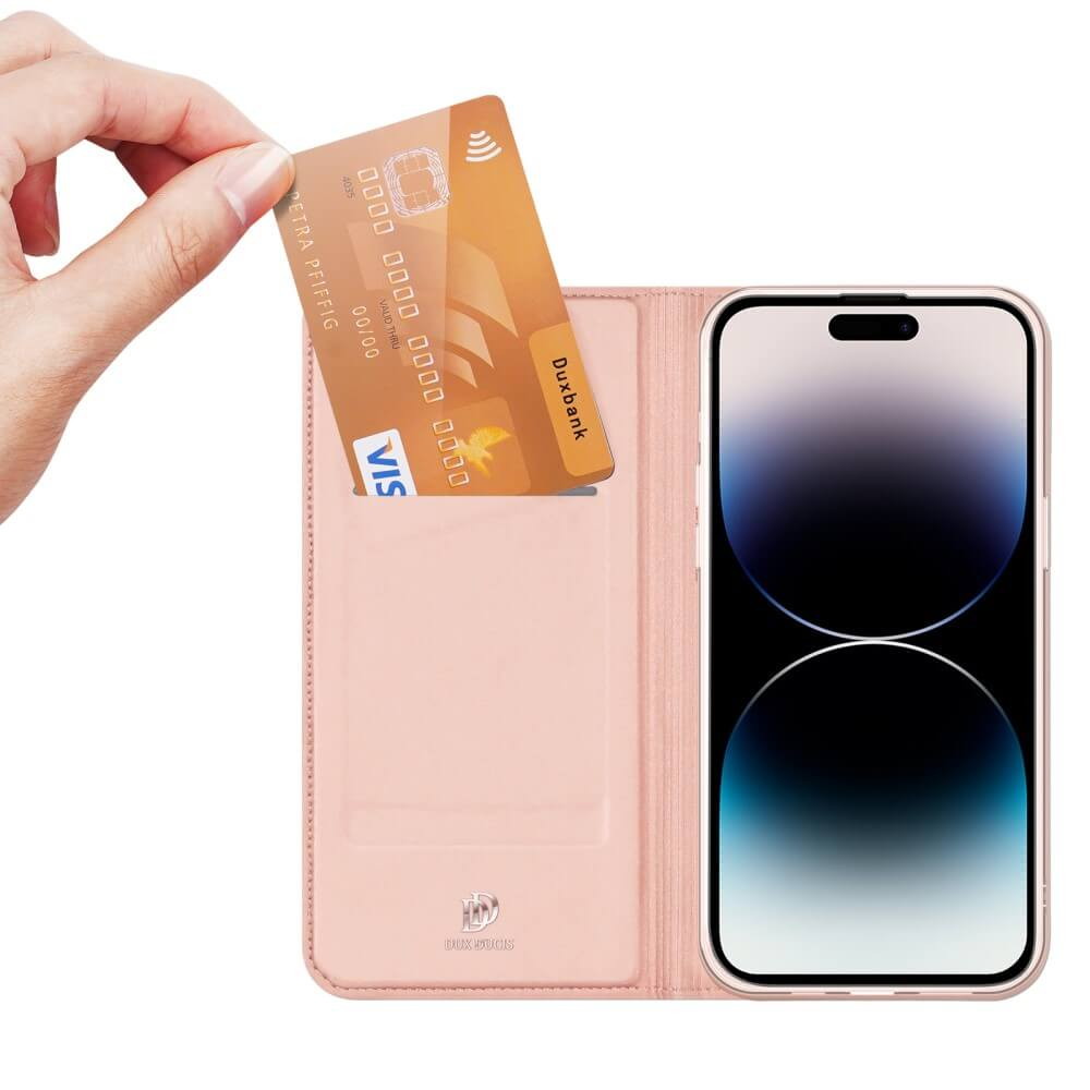 Mano che tiene carta di credito sopra custodia rosa con telefono dentro. La carta è oro e ha numeri.