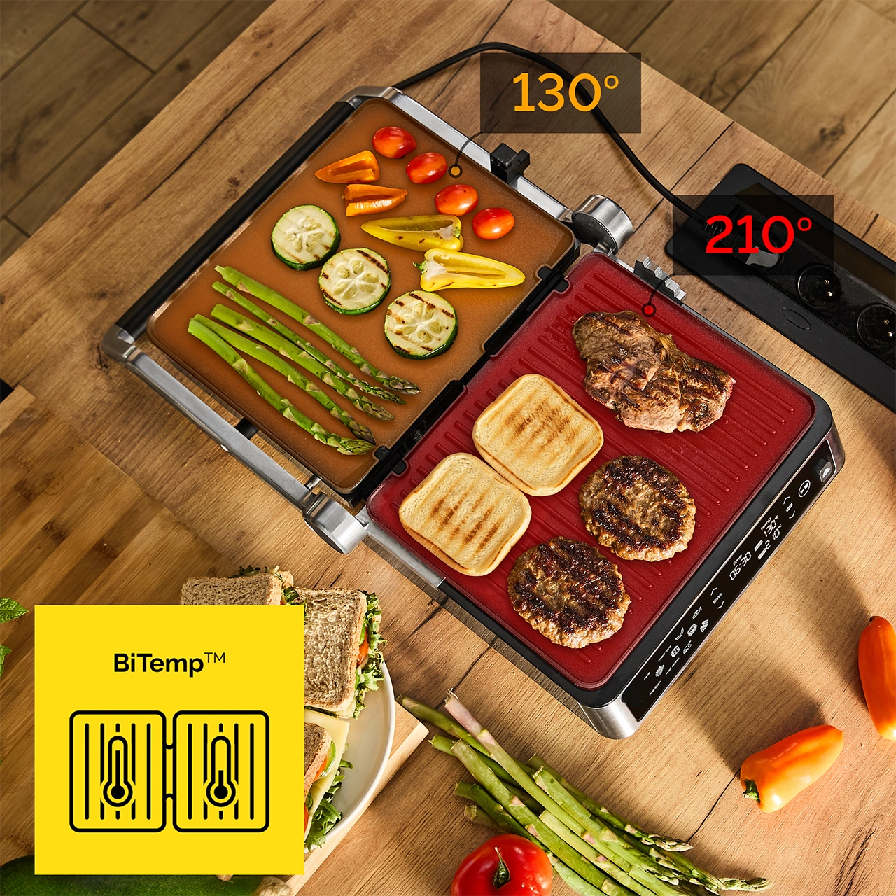 Grill elektryczny z warzywami i mięsem. Wyświetlana temperatura. Tosty, burgery, stek, pomidory, papryka, szparagi i cukinia na grillu.