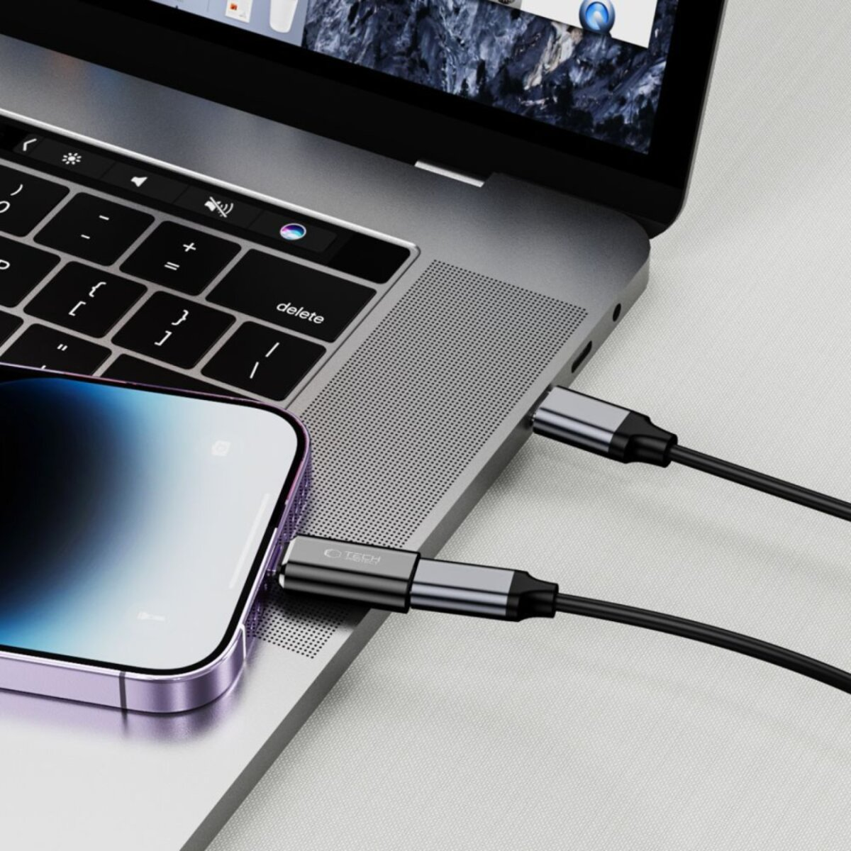 Un téléphone est connecté à un ordinateur portable via un câble. Le téléphone est en bas à gauche, l'ordinateur portable en arrière-plan.
