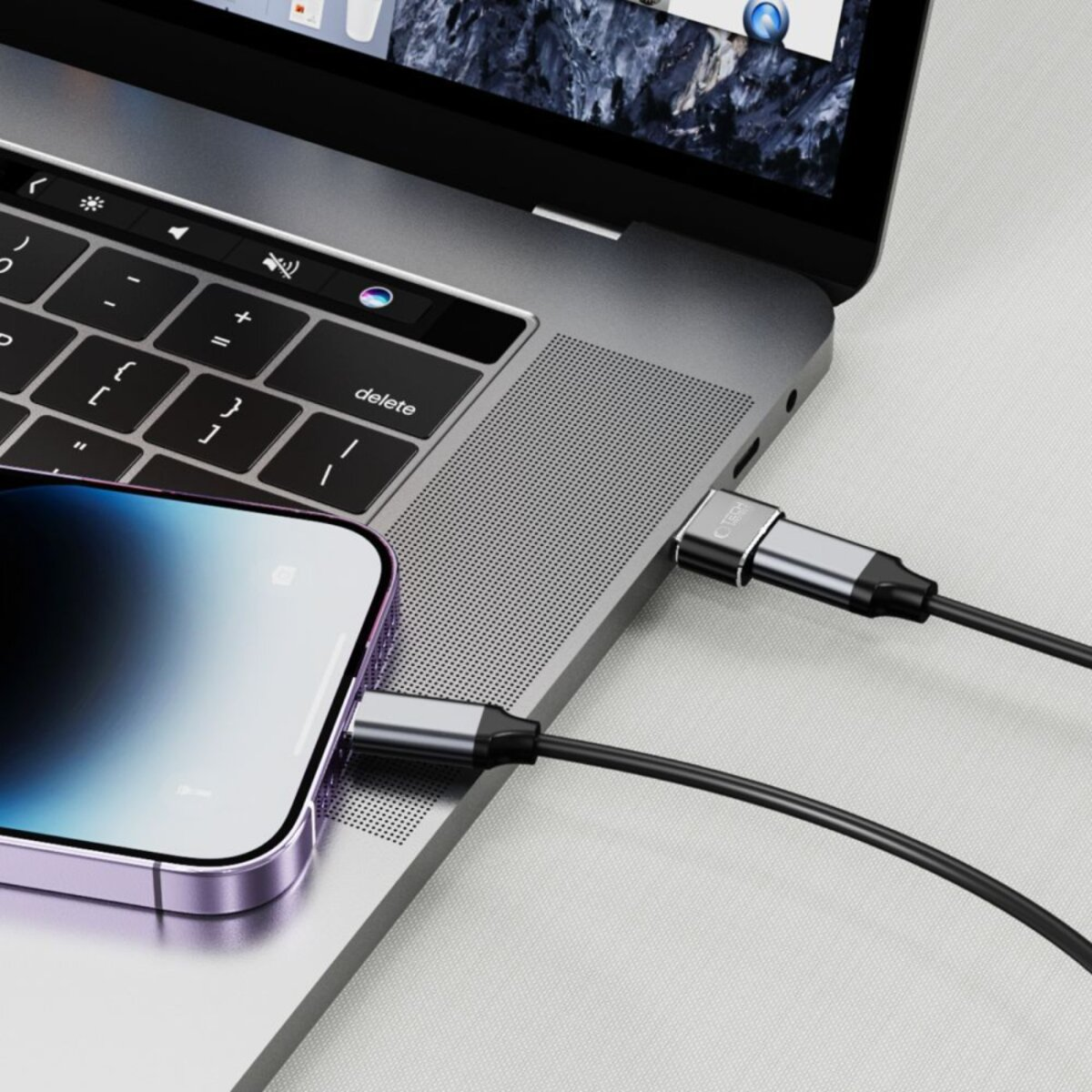 Een laptop en een smartphone verbonden via USB-C-kabels. De laptop is open en de telefoon wordt opgeladen. Kabels zijn zwart en zilver.