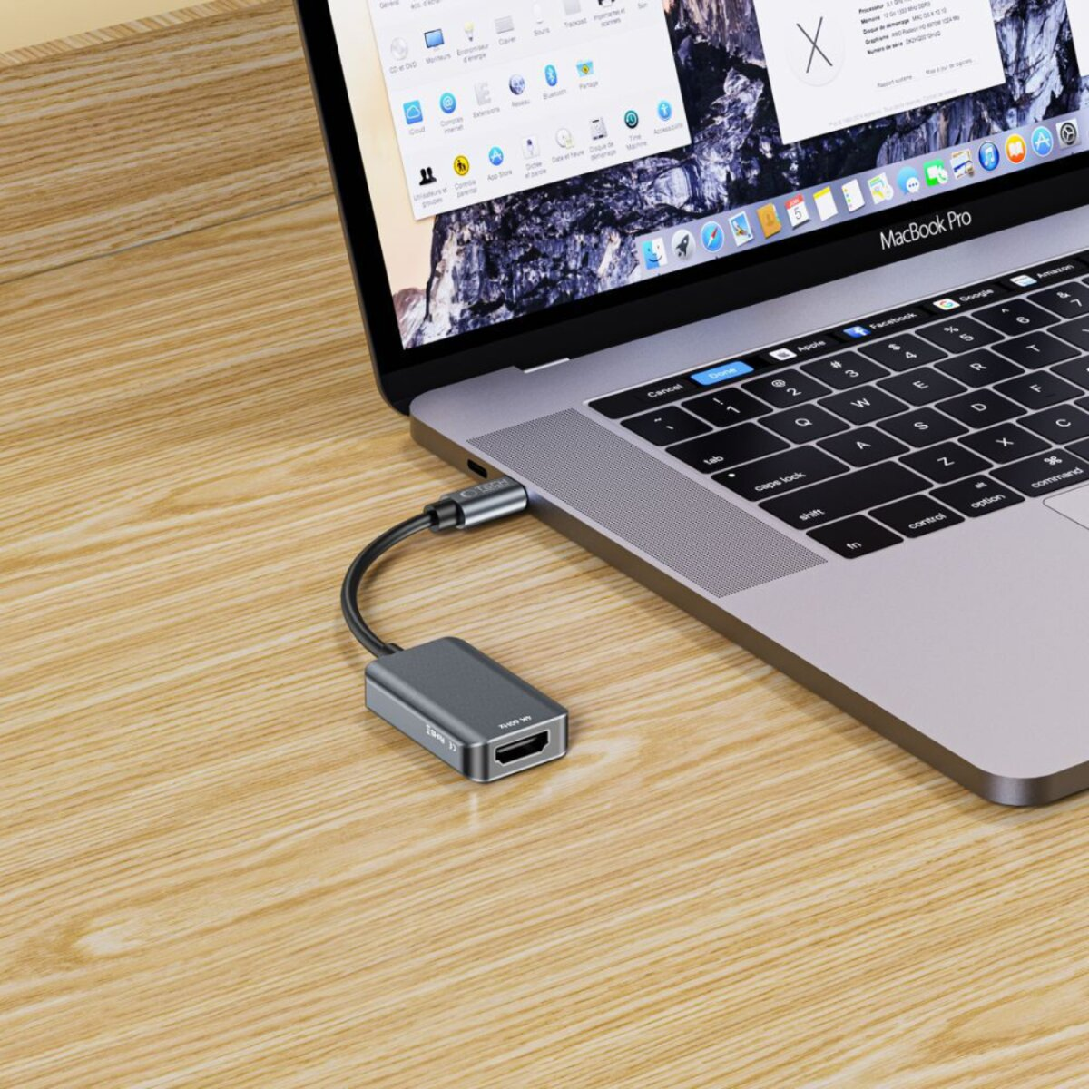 Un ordinateur portable avec un adaptateur gris connecté est sur une surface en bois. L'écran affiche une fenêtre. L'adaptateur a un port HDMI.