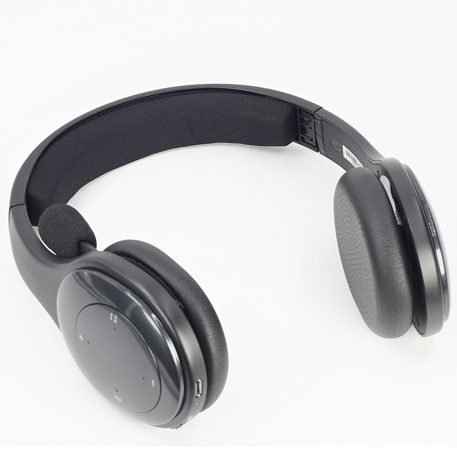 Cuffie nere su superficie bianca. Le cuffie hanno un design over-ear con microfono integrato.