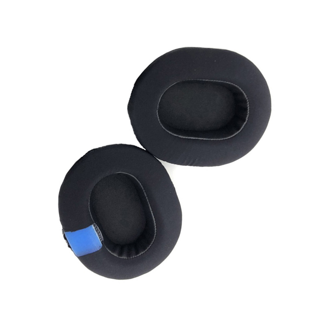 Two black headphone ear cushions on a white background. One has a blue patch. Oval shape with a central opening.