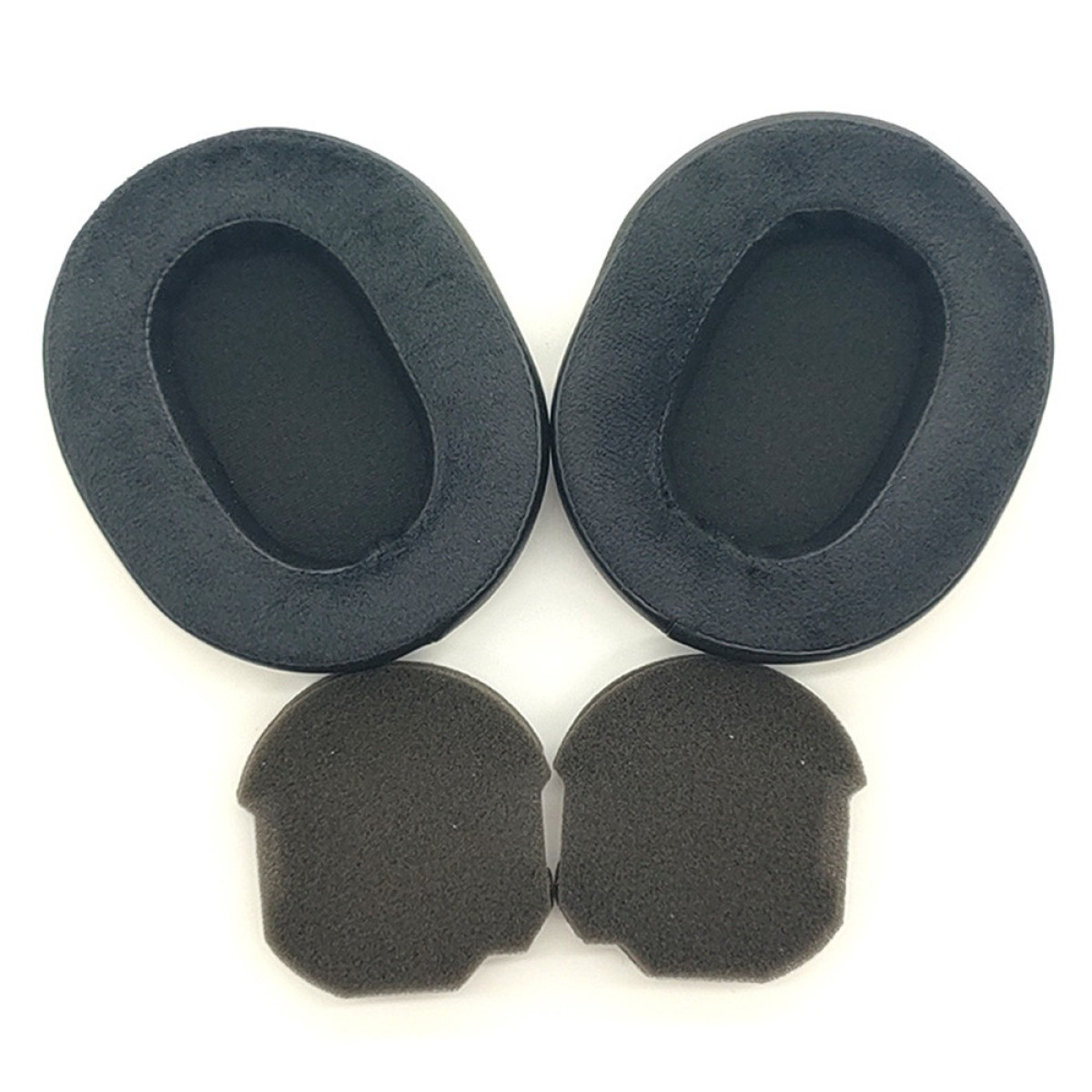 Due grandi cuscinetti neri e due piccoli cuscinetti in schiuma grigio scuro sono disposti su una superficie bianca. Tutto per le cuffie.