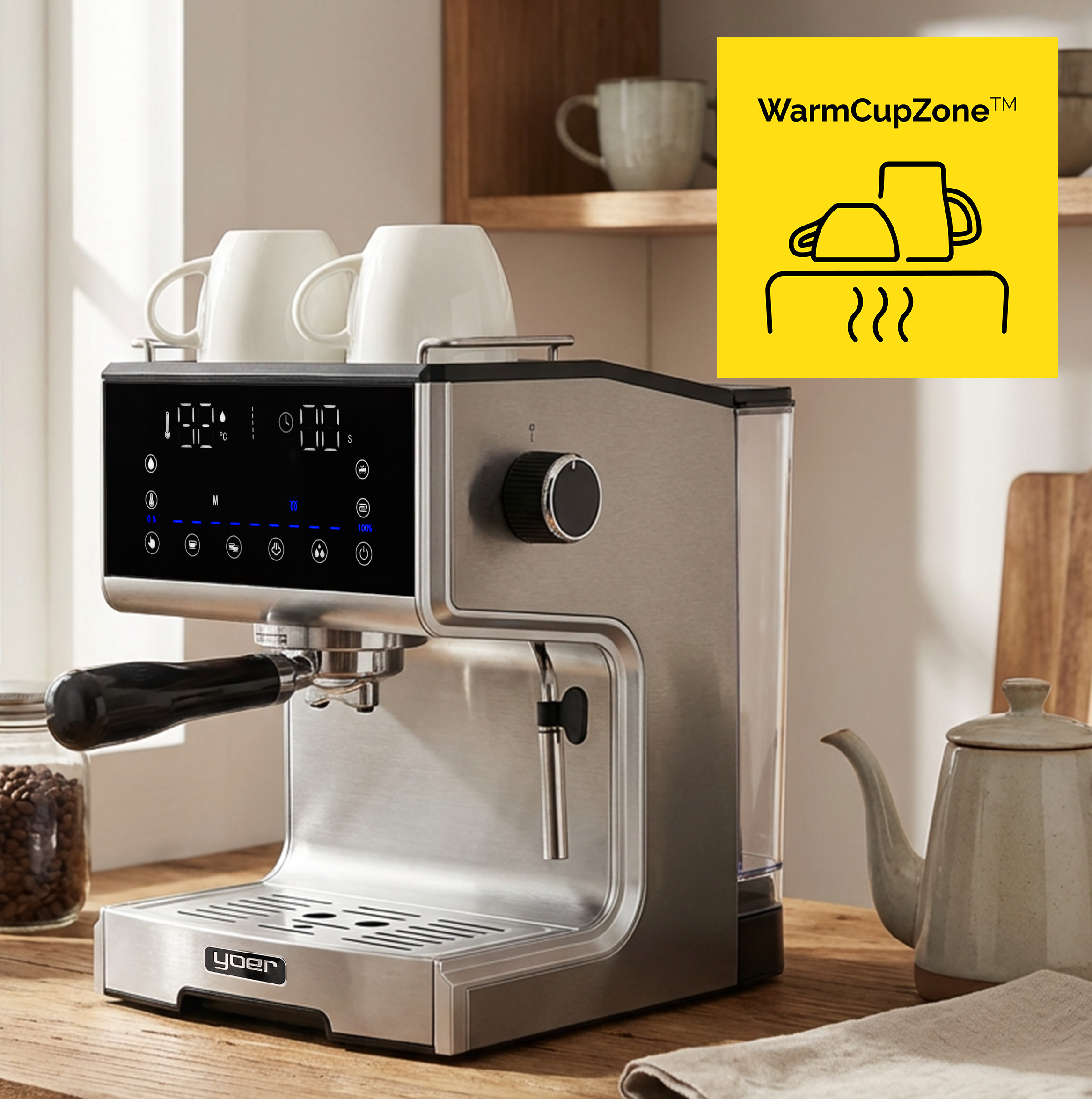 Ekspres do kawy z dwoma filiżankami na górze, na drewnianym stole. Obok czajnik i słoik z fasolą.