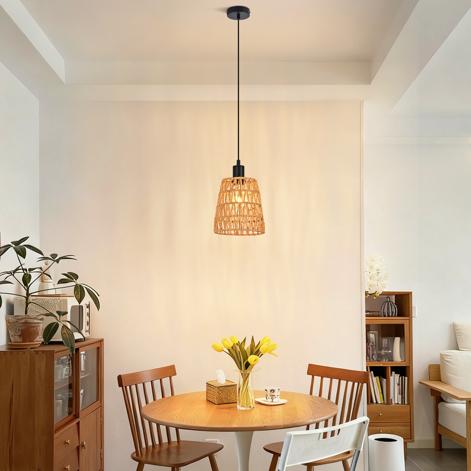 Esszimmer mit gewebter Hängelampe, rundem Tisch, Stühlen und Vase mit gelben Blumen.