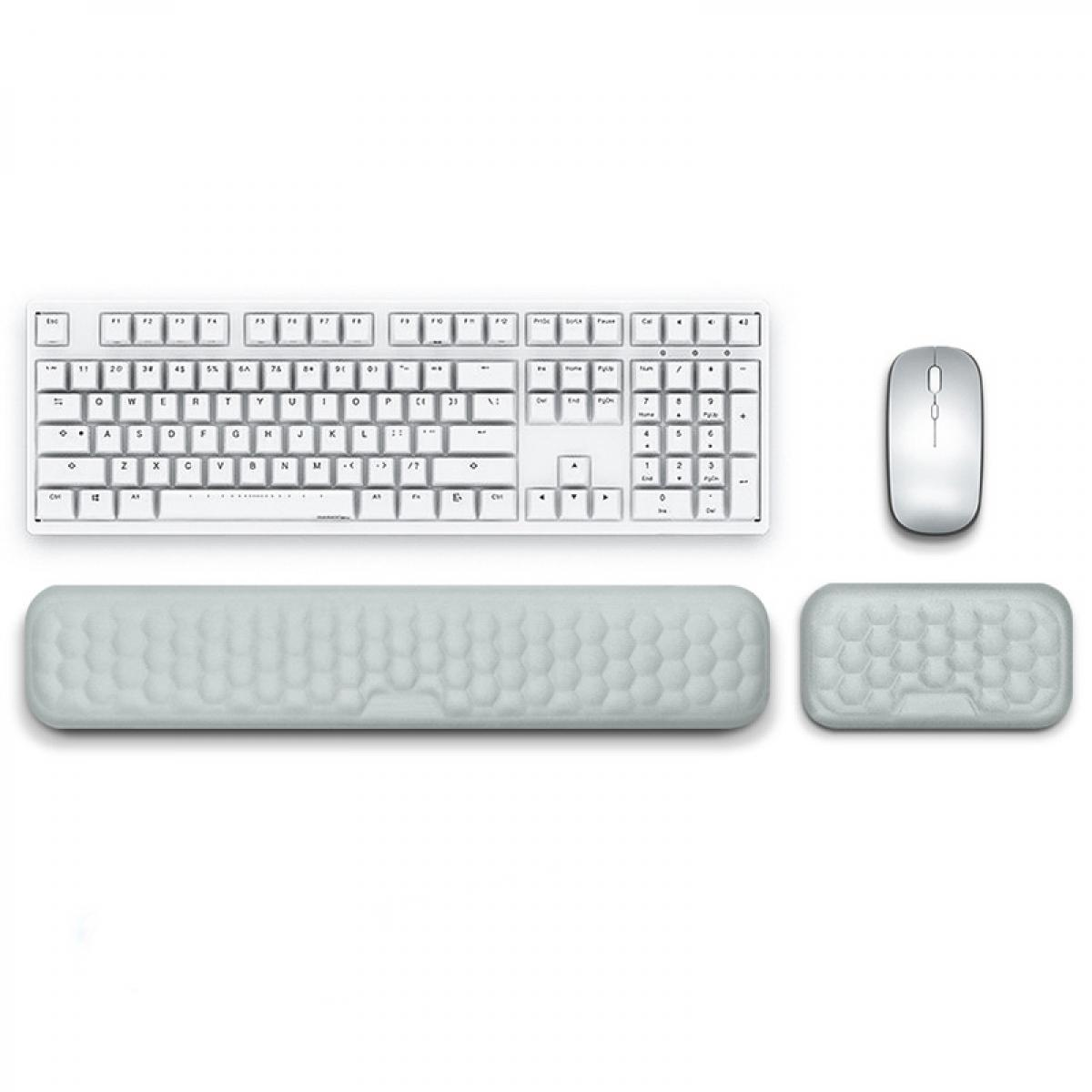 Eine weiße Tastatur, Maus und zwei Handgelenkstützen liegen auf einer weißen Oberfläche. Die Handgelenkstützen haben ein Wabenmuster.