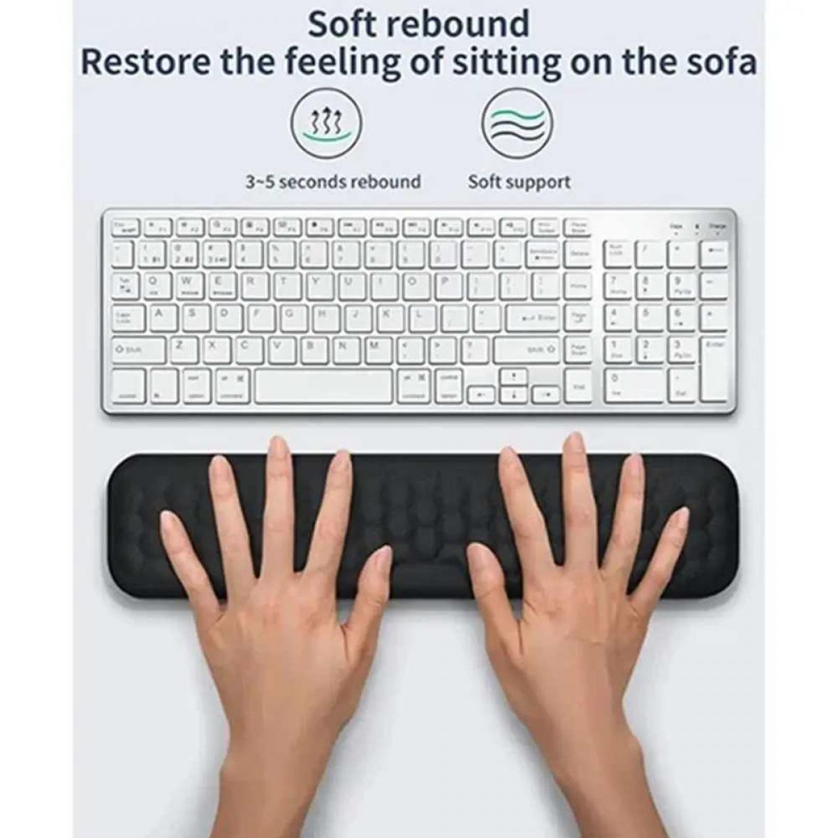 Hände auf einer schwarzen Handgelenkstütze, darüber eine weiße Tastatur. Oben steht weicher Rückprall und Gefühl wie Sofa.