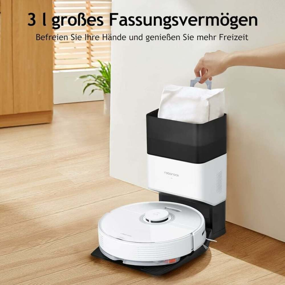 Ein weißer und schwarzer Roboter-Staubsauger mit Ladestation. Eine Hand hält eine weiße Tasche auf der Station.